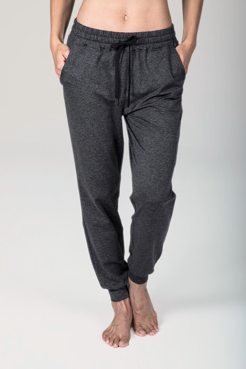 Person wearing dark gray jogger pants on a light gray background