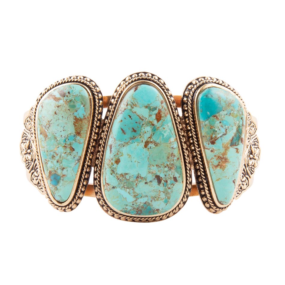 Turquoise stone bracelet with gold accents on a white background