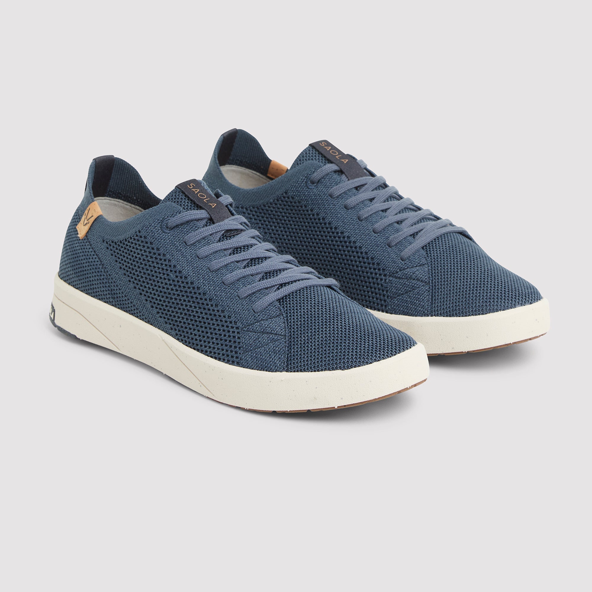 A pair of blue mesh low-top sneakers with white soles, shown from a three-quarters angle on a light gray background.