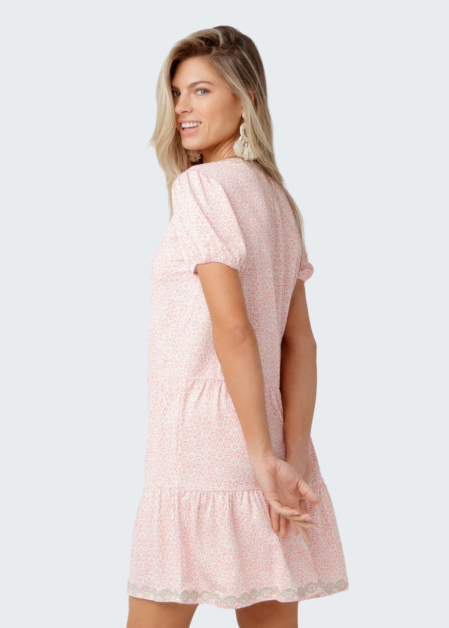 Woman wearing a pink dress with a white background