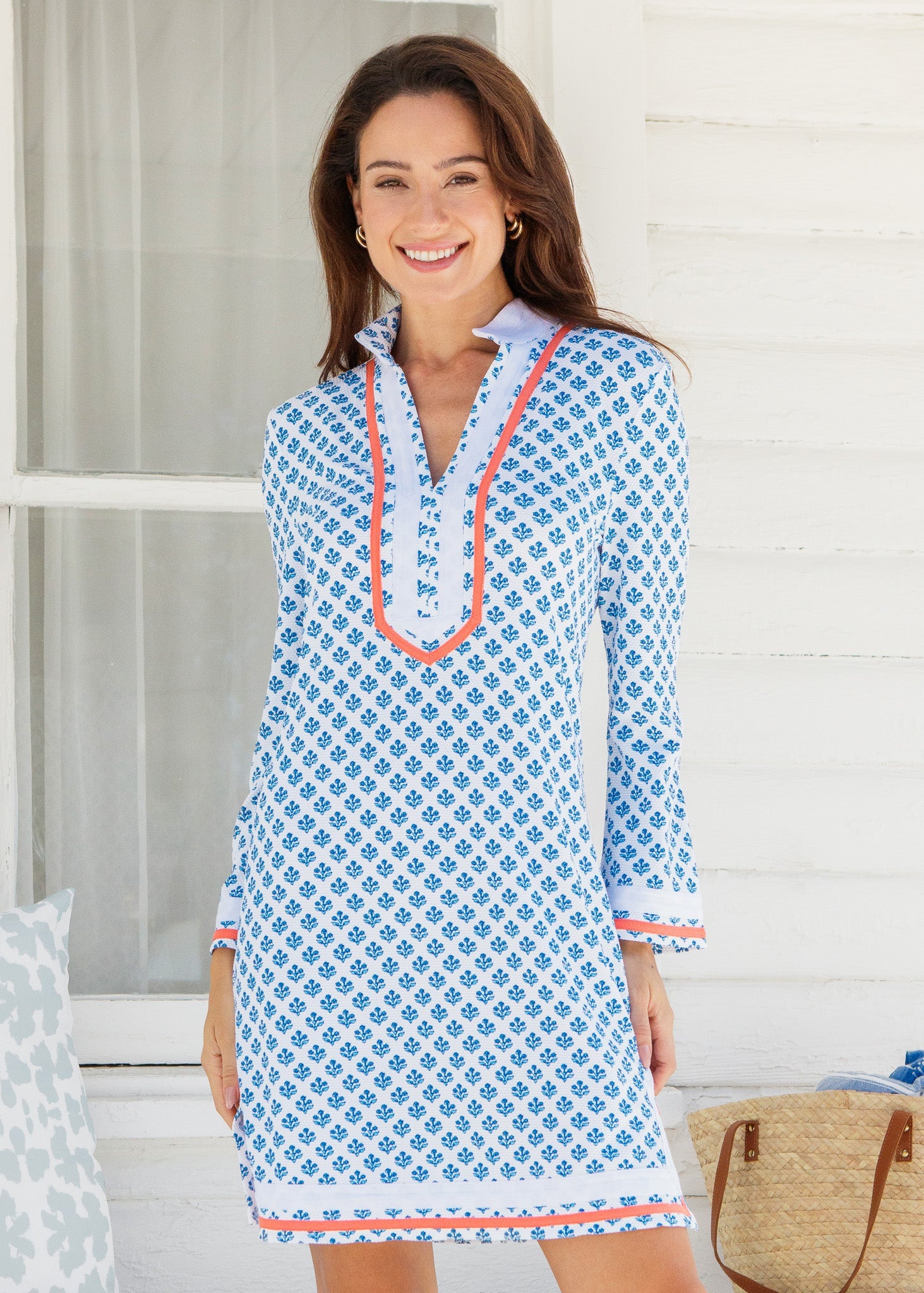 Woman wearing a blue patterned dress with white background