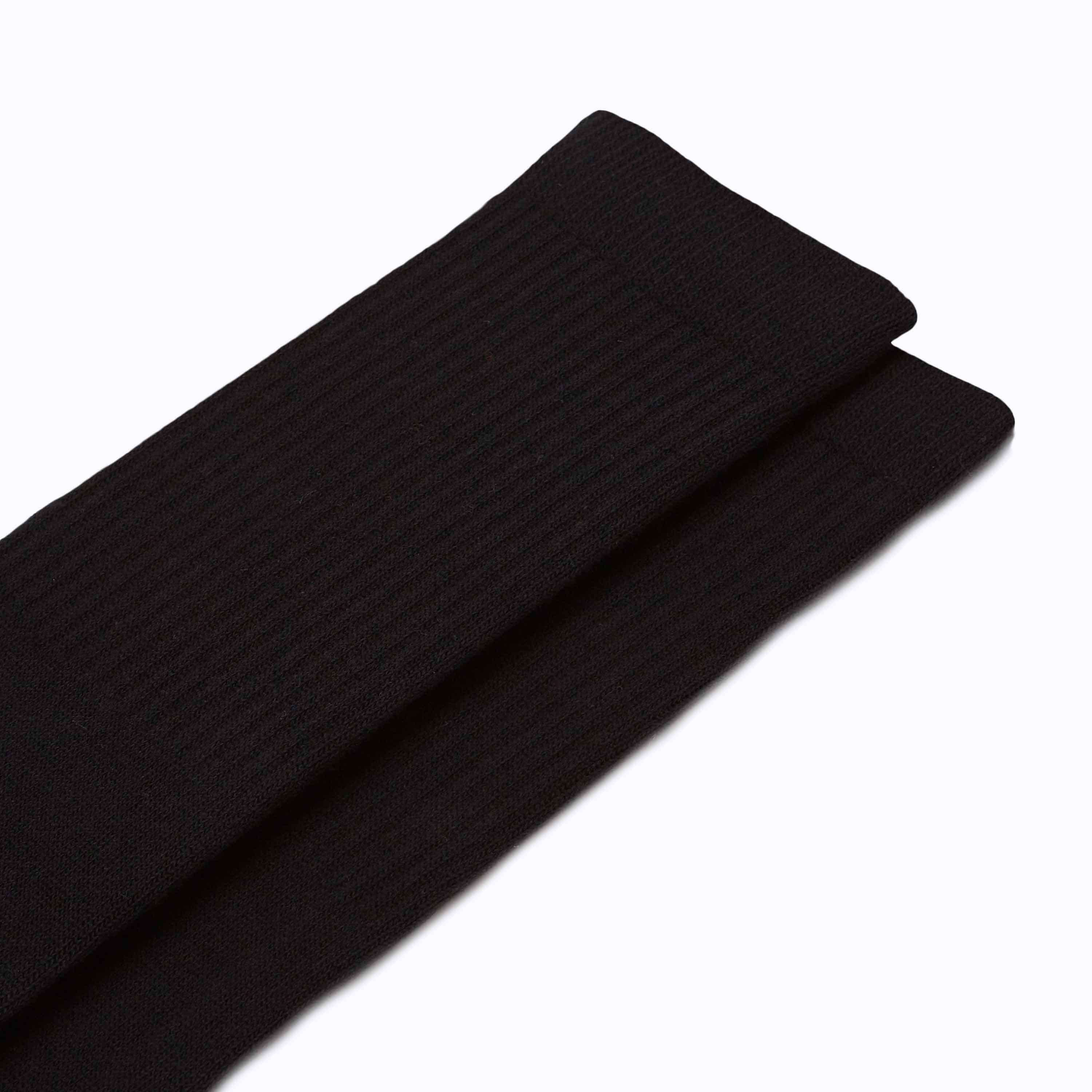 Two black ribbed socks on a white background