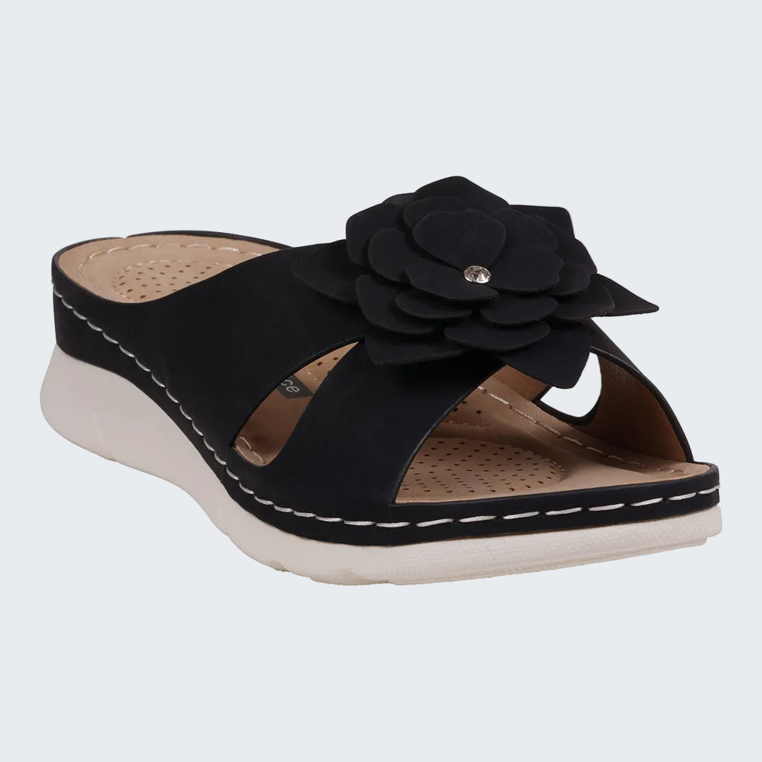 Black sandal with a flower detail on a white background