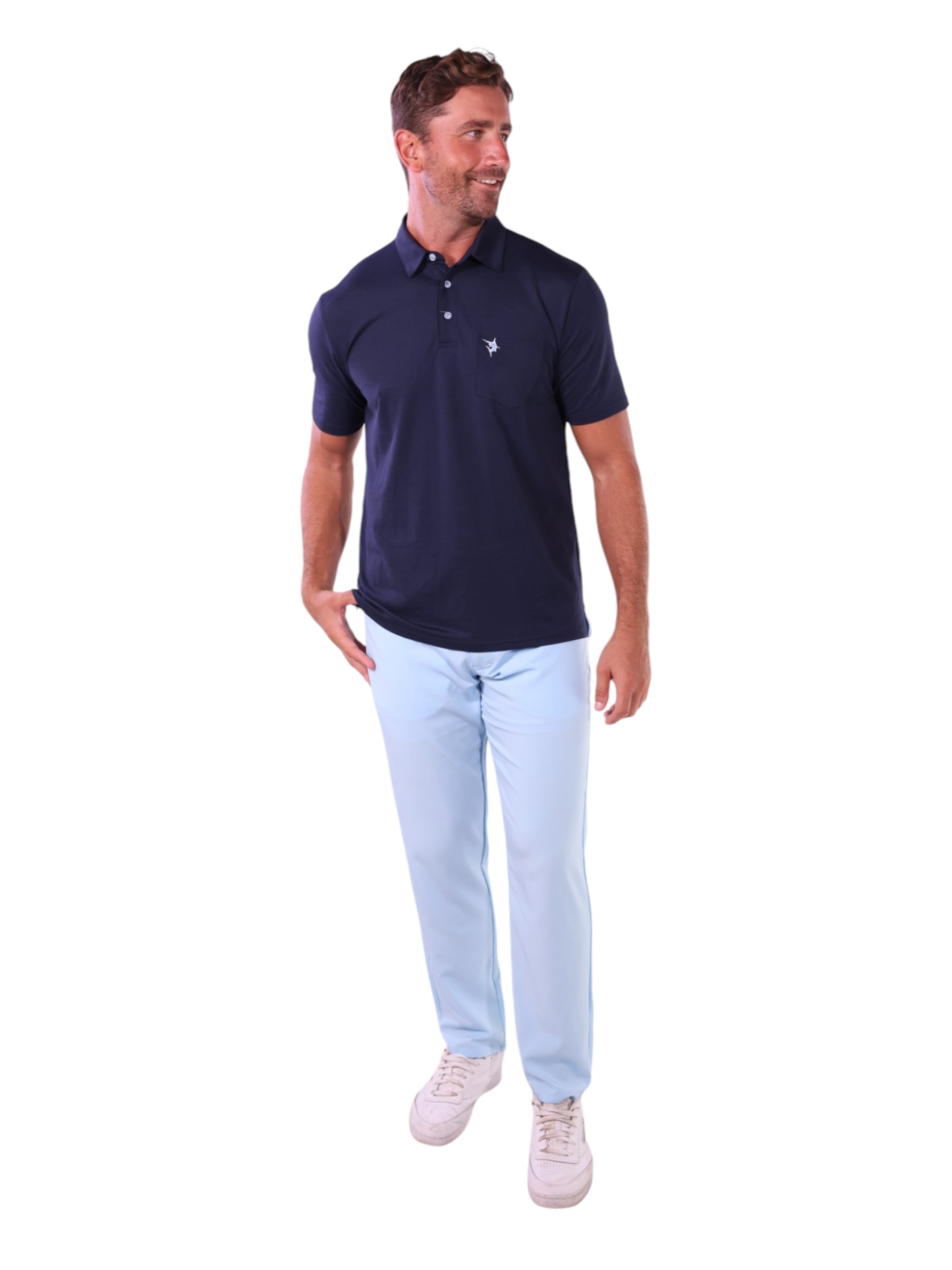 Man wearing a navy polo shirt and light blue pants on a white background