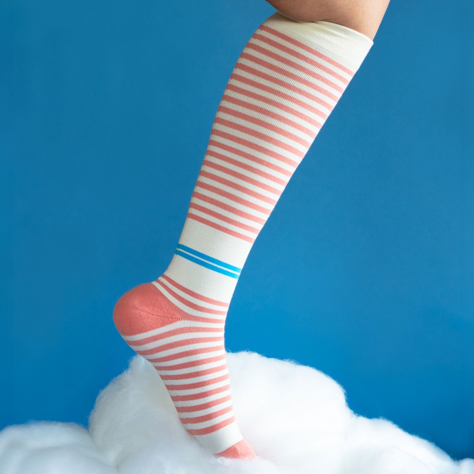 Knee-high striped socks with pink and white stripes on a blue background
