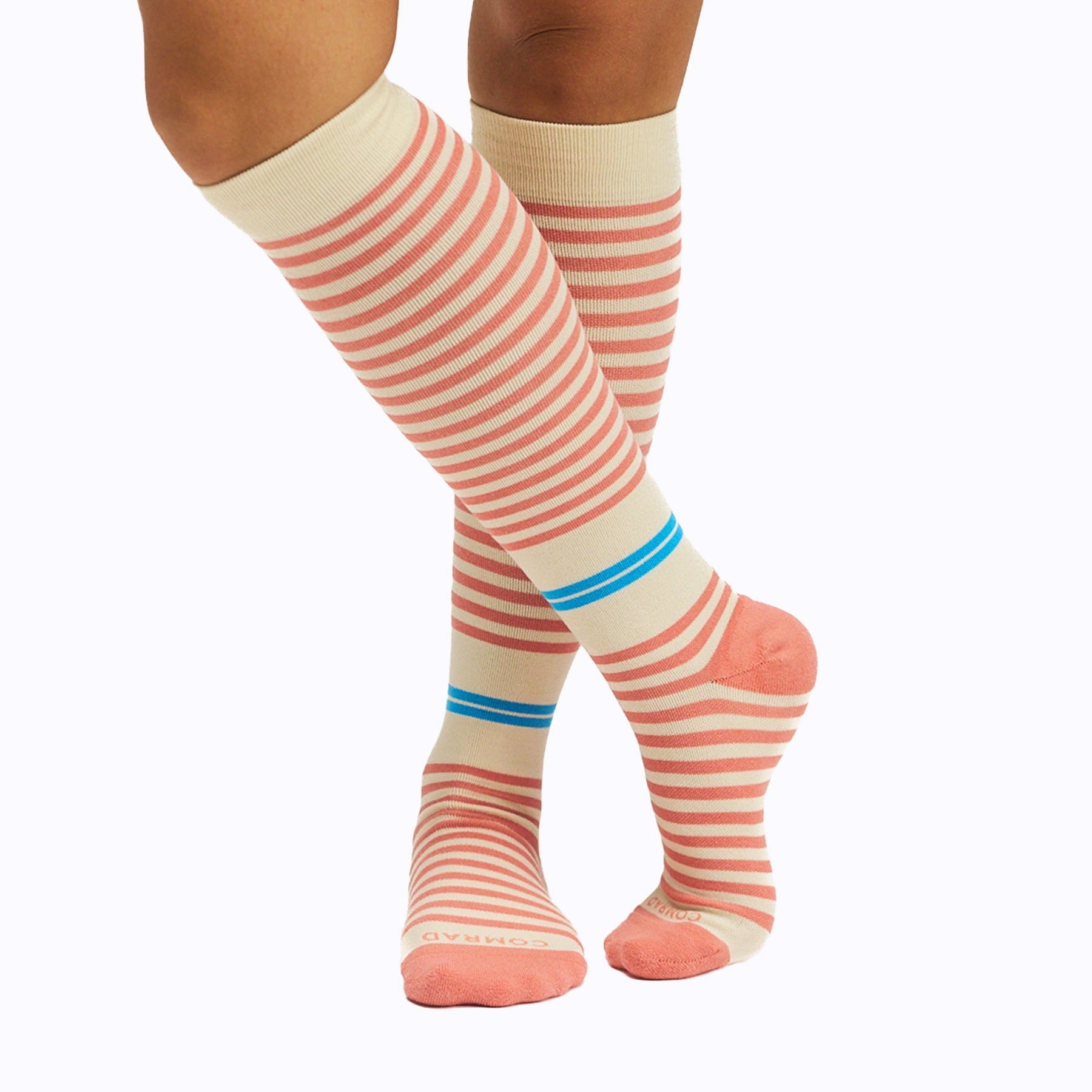 Knee-high socks with pink and white stripes and blue accents on a white background