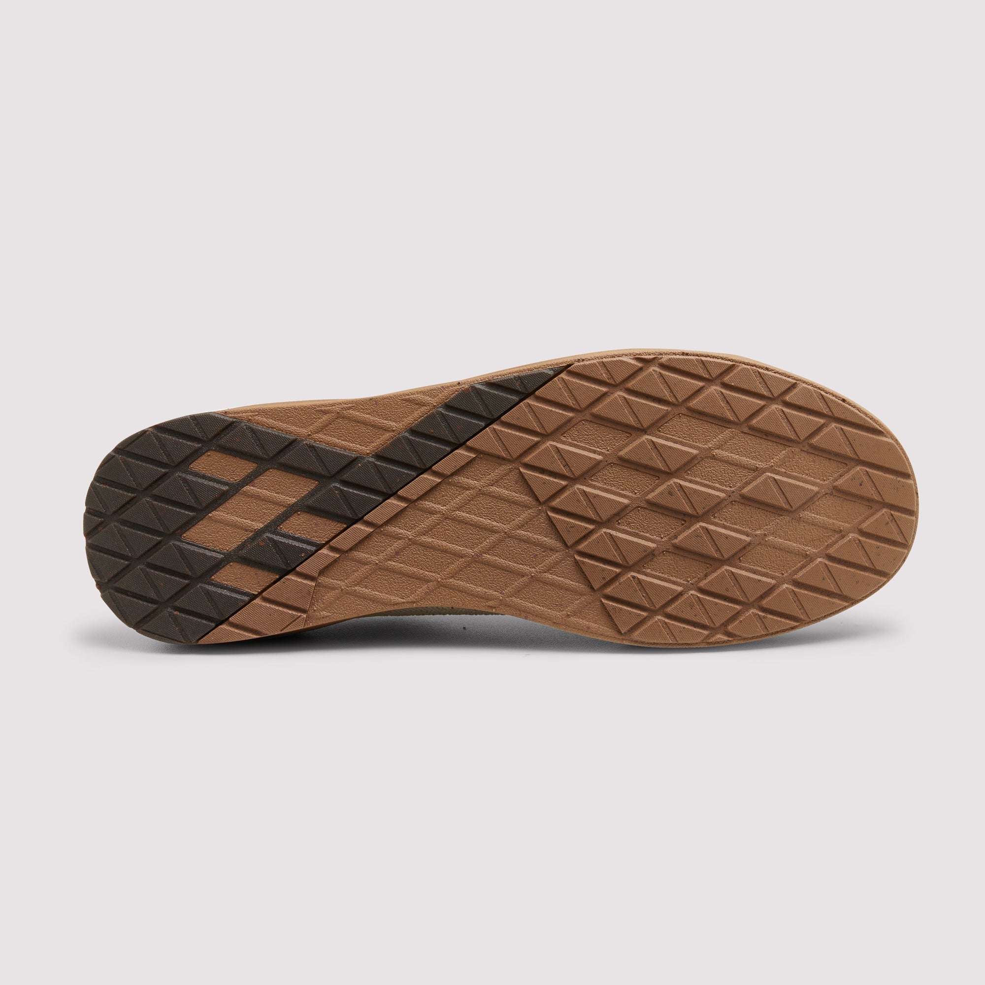 The bottom sole of a shoe, showing a brown textured diamond-patterned tread with a black rubber accent on the heel, photographed on a light gray background.