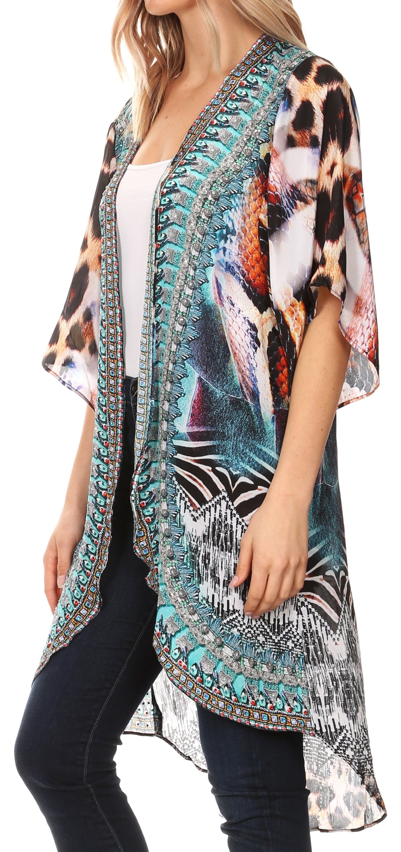 Woman wearing a colorful patterned kimono over a white top and black pants on a white background