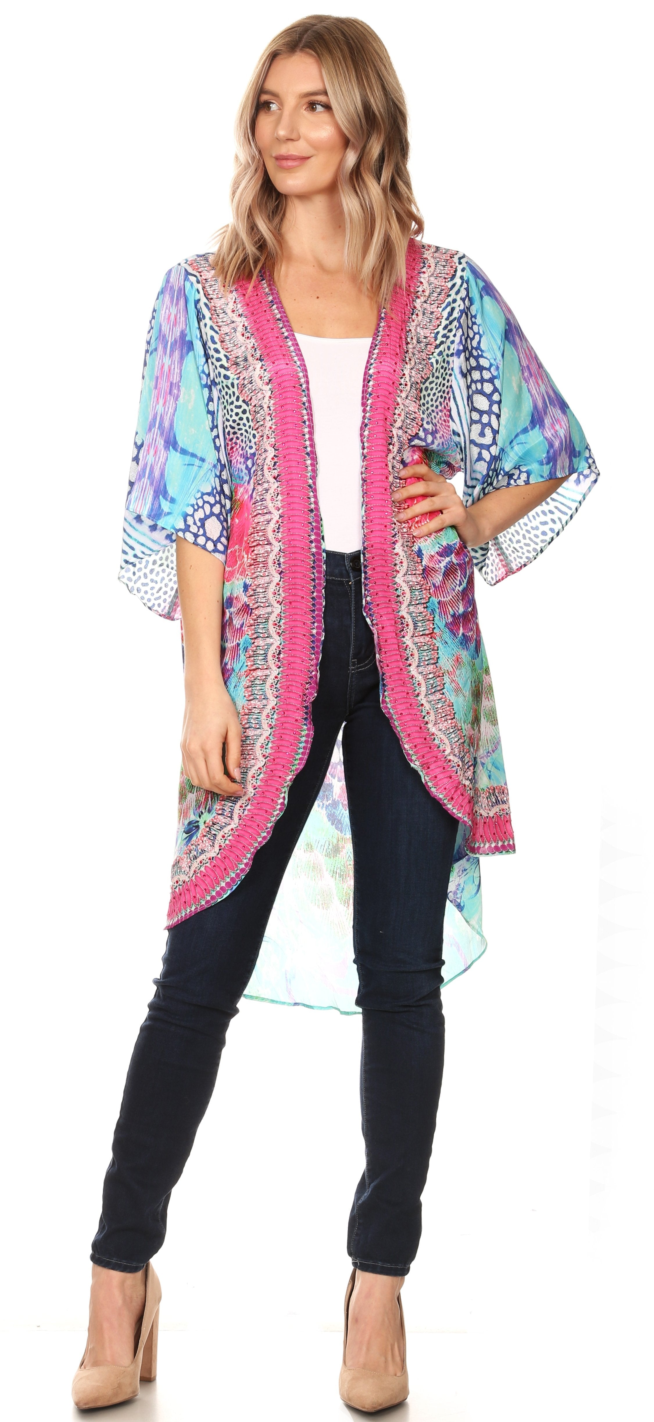 Woman wearing a colorful kimono-style jacket over a white top and black pants.