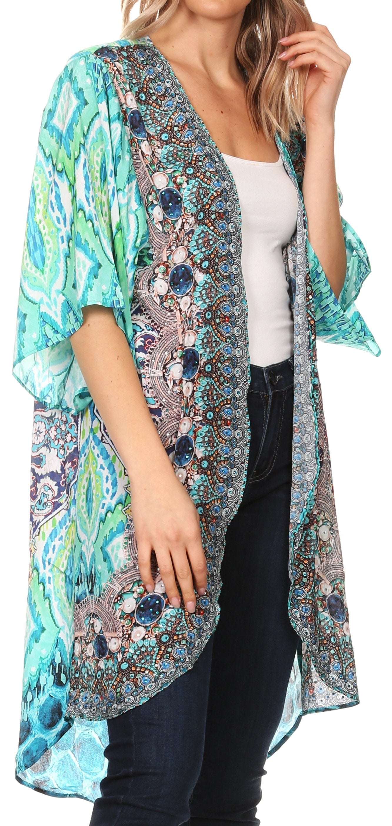 Woman wearing a colorful patterned kimono over a white top and black pants on a white background