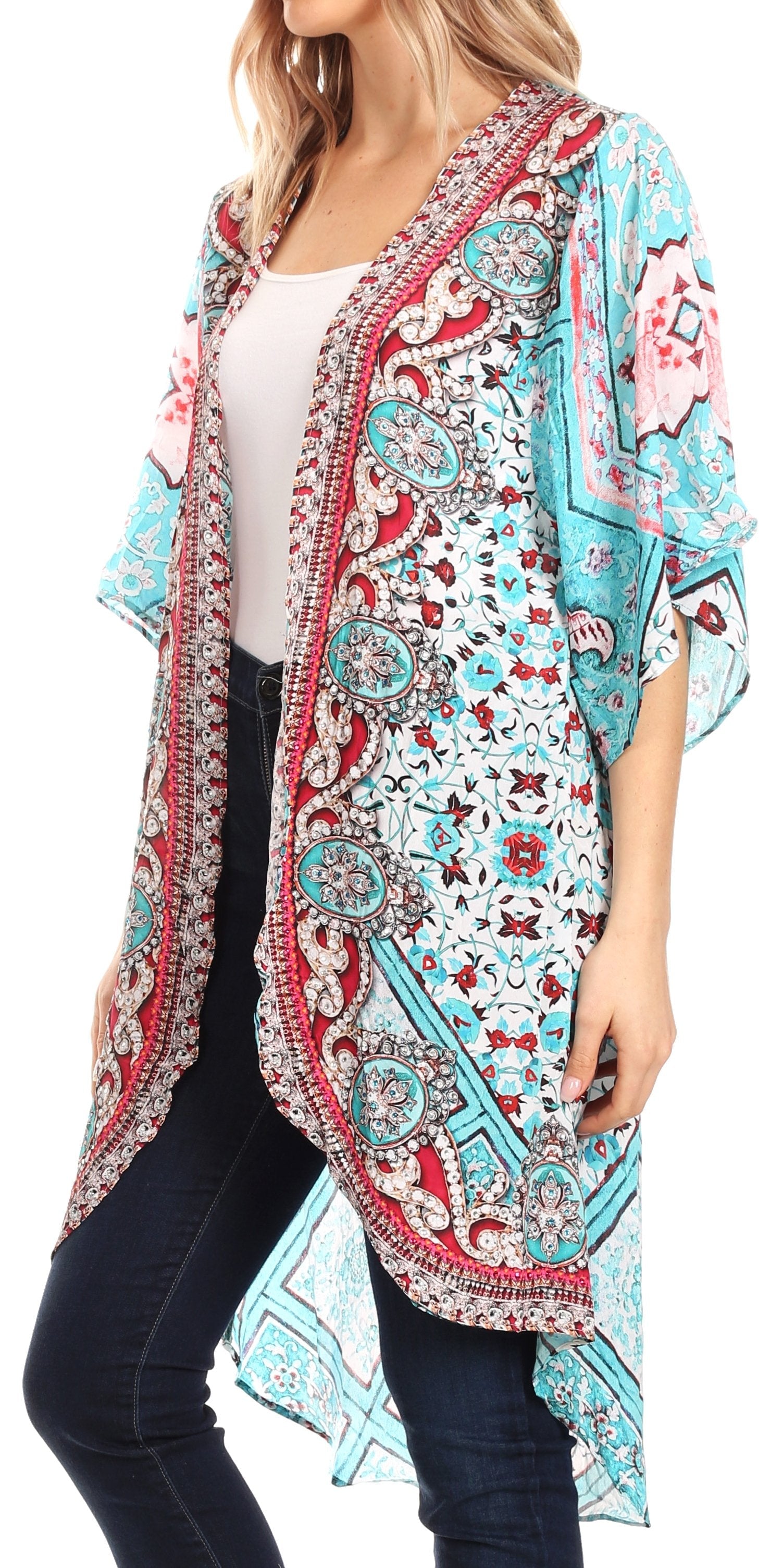 Woman wearing a colorful patterned kimono over a white top and black pants.