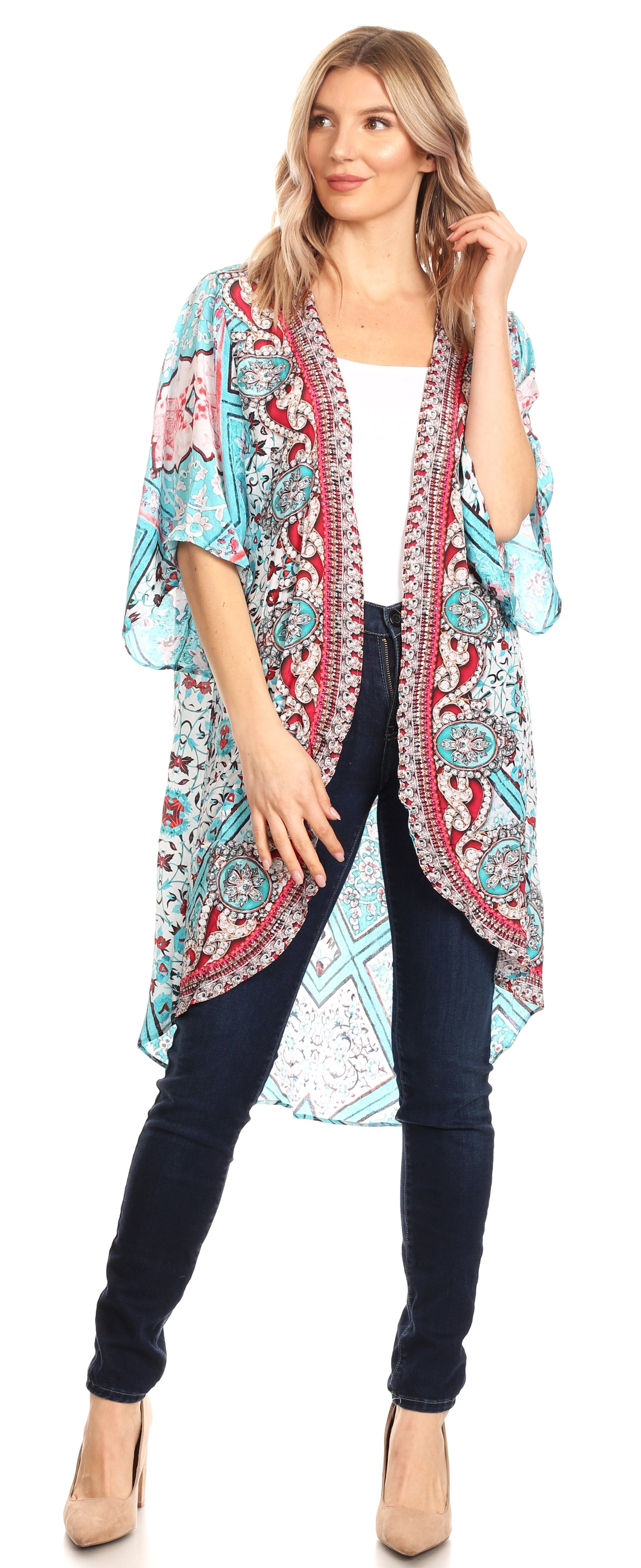 Woman wearing a colorful patterned kimono over a white top and dark pants on a white background