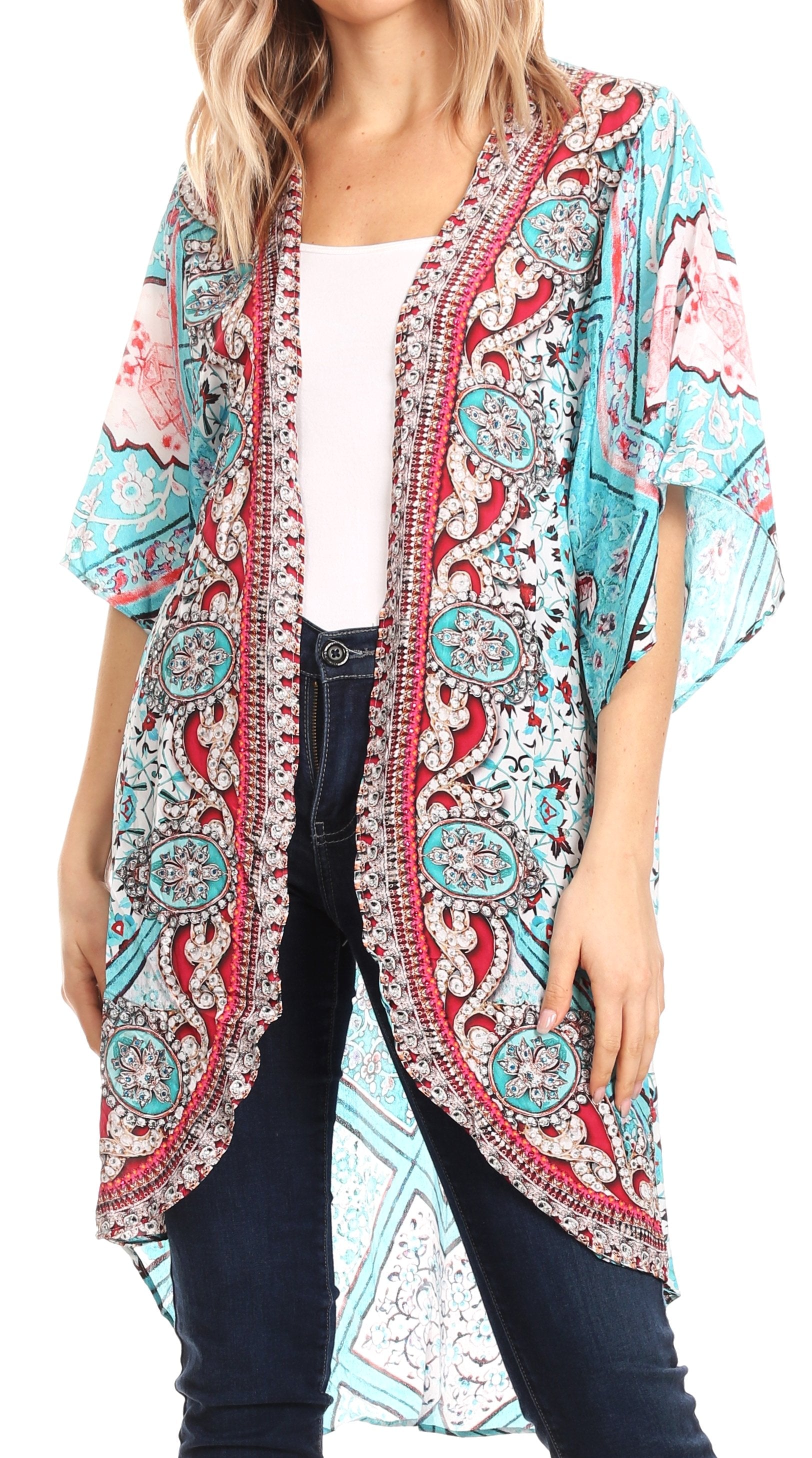 Woman wearing a colorful patterned kimono over a white top and jeans on a white background
