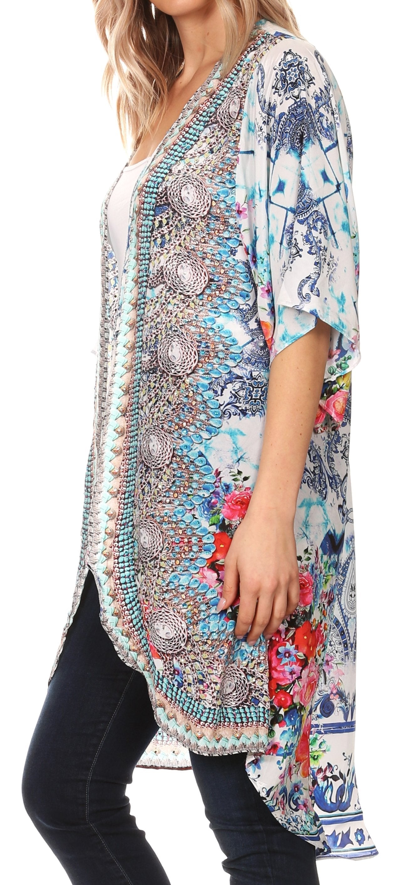 Woman wearing a colorful patterned kimono-style top with black pants.