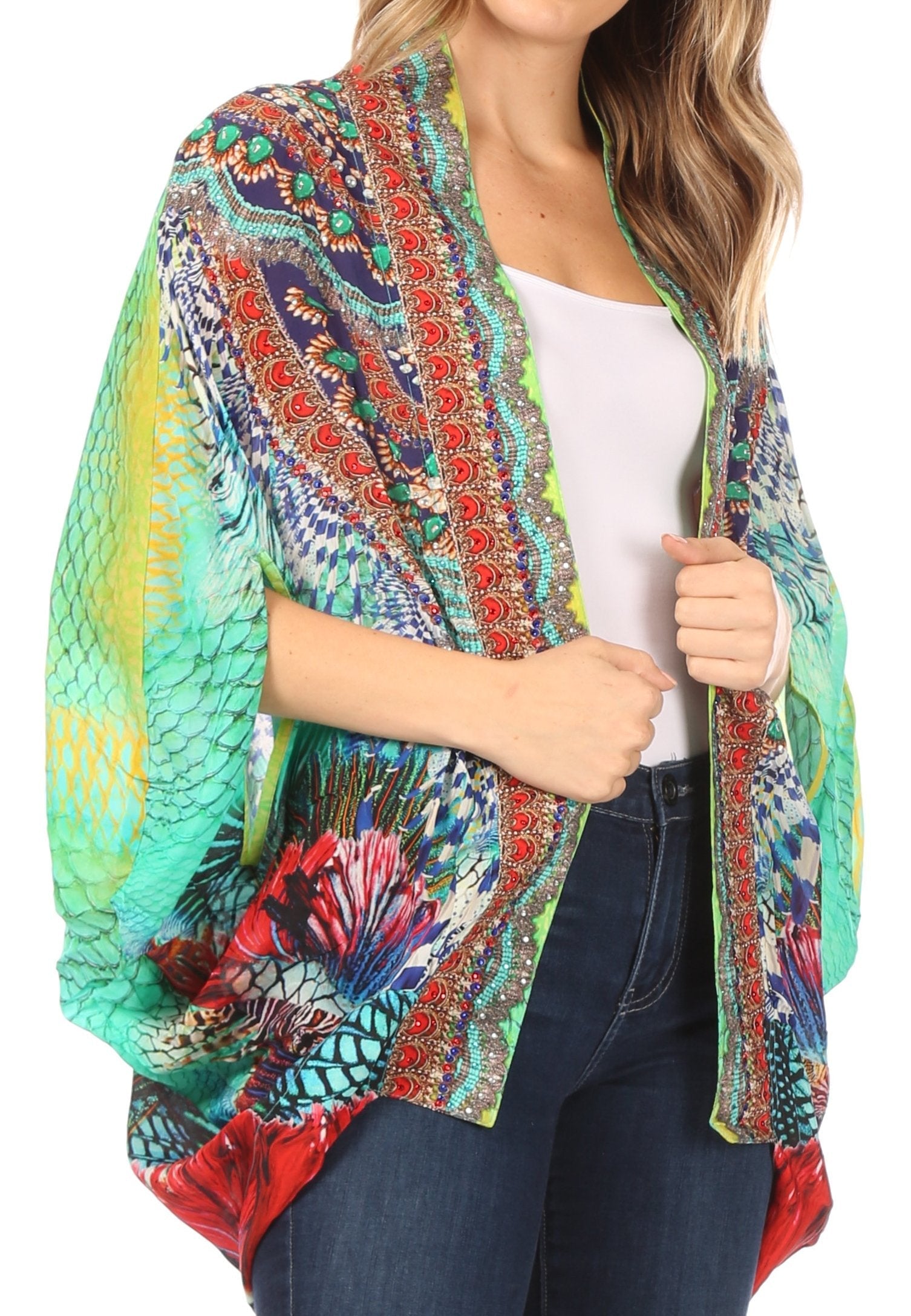 Woman wearing a colorful patterned kimono over a white top and jeans on a white background