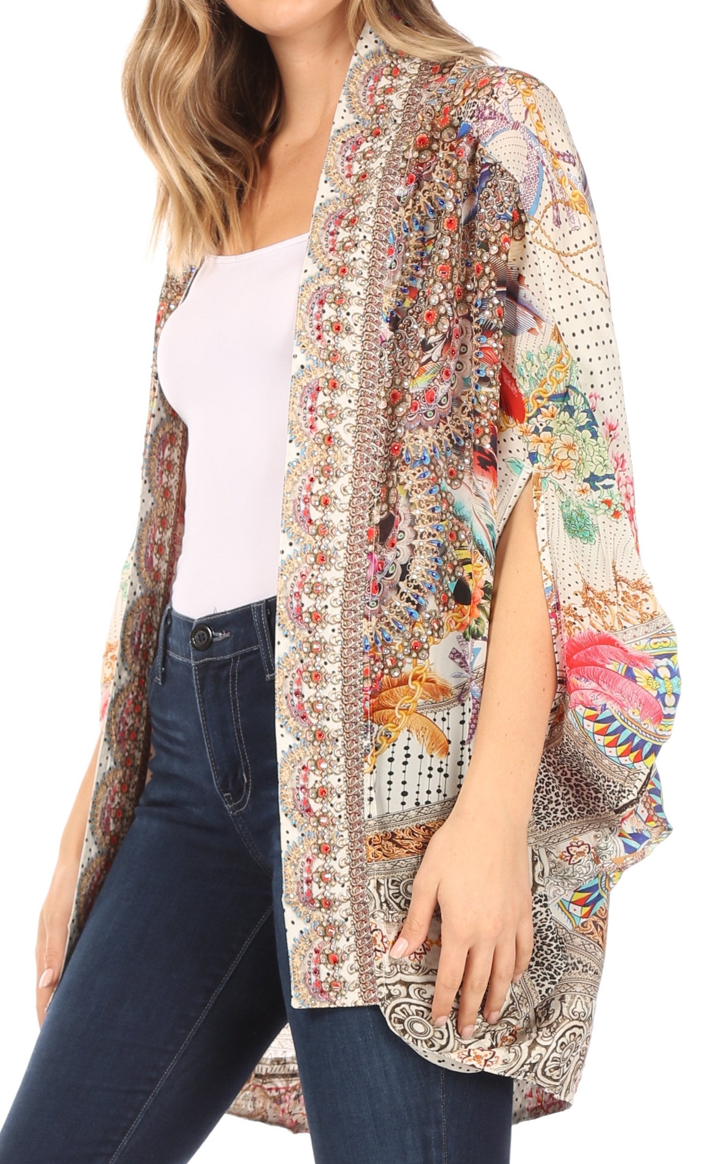 Woman wearing a colorful patterned kimono over a white top and blue jeans on a white background