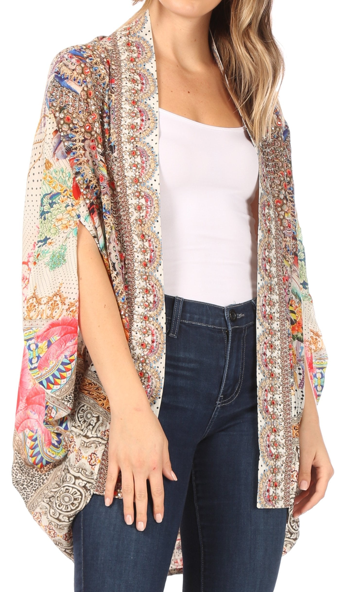 Woman wearing a colorful patterned kimono over a white top and blue jeans on a white background