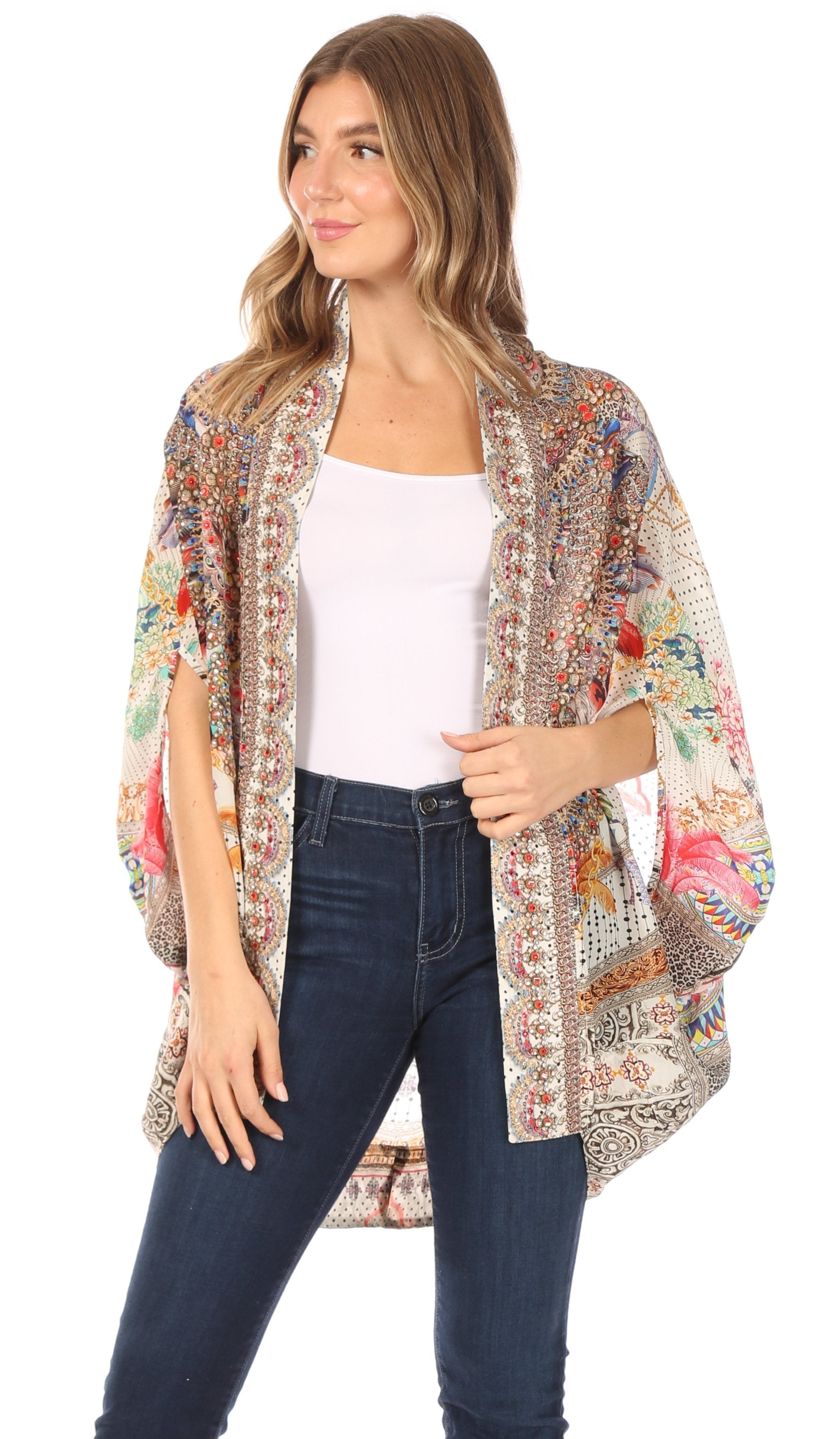 Woman wearing a colorful patterned kimono over a white top and jeans on a white background