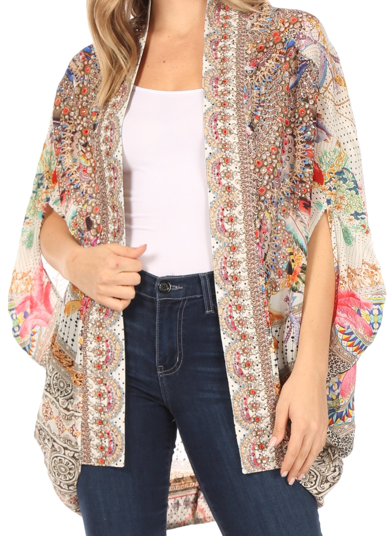 Woman wearing a colorful patterned kimono over a white top and blue jeans on a white background