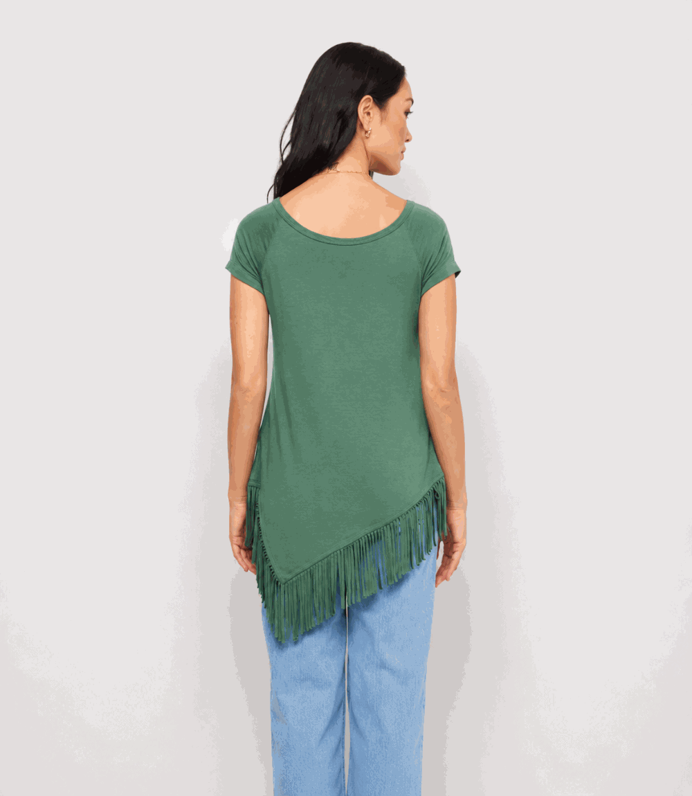 Woman wearing a green fringed top and blue pants on a white background