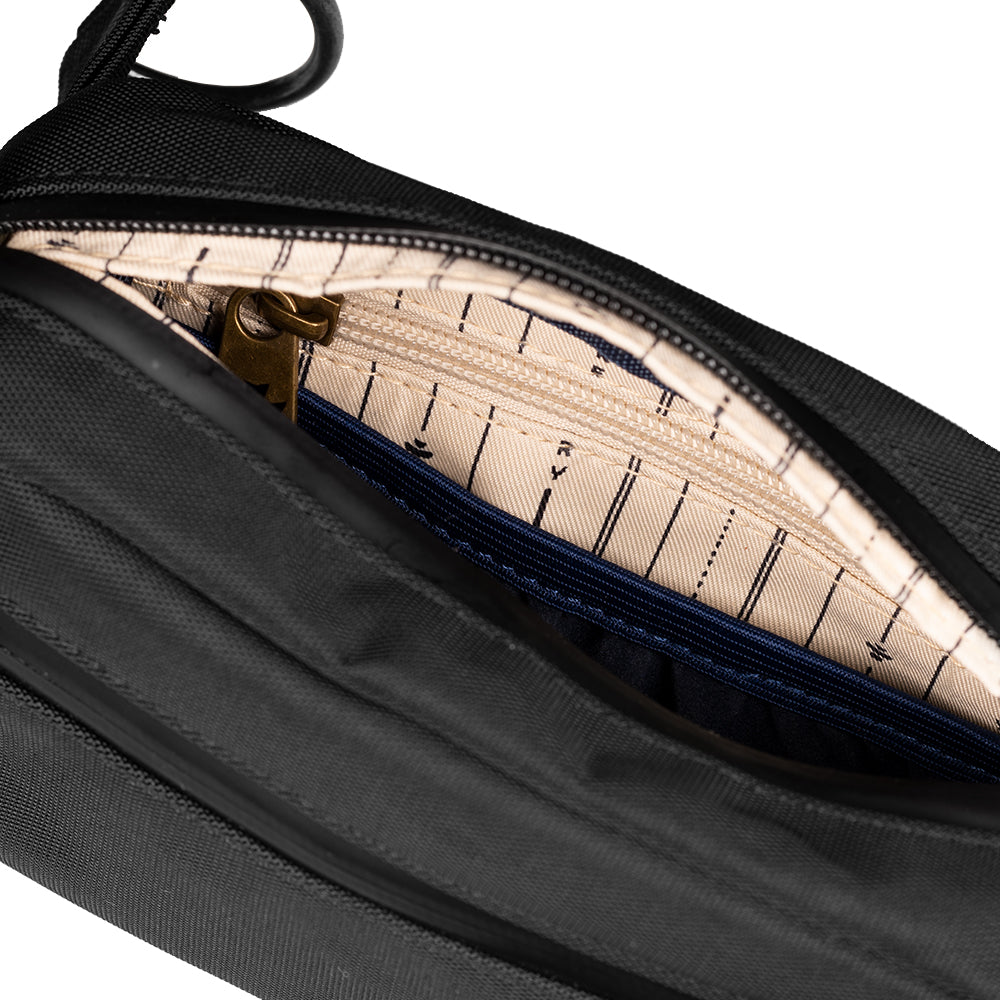 Black bag with a zipper open, revealing a patterned interior.