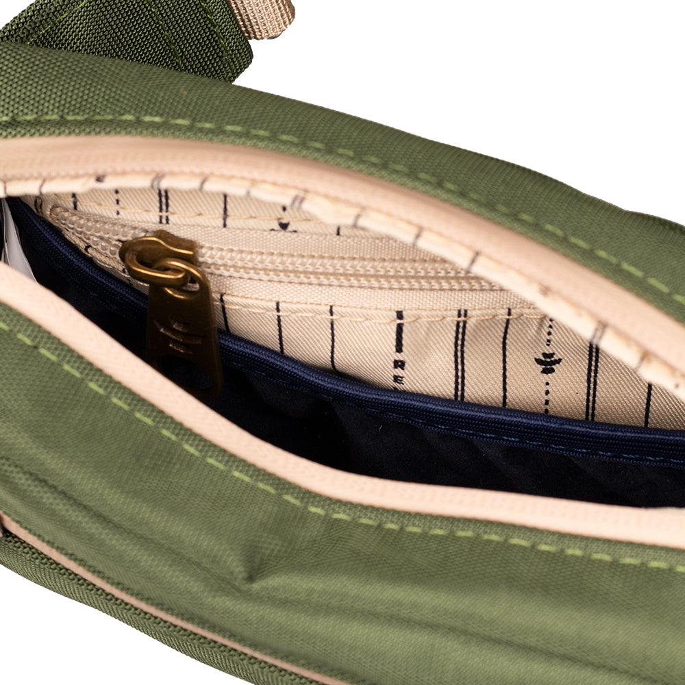 Green bag with a gold zipper and striped lining on a white background
