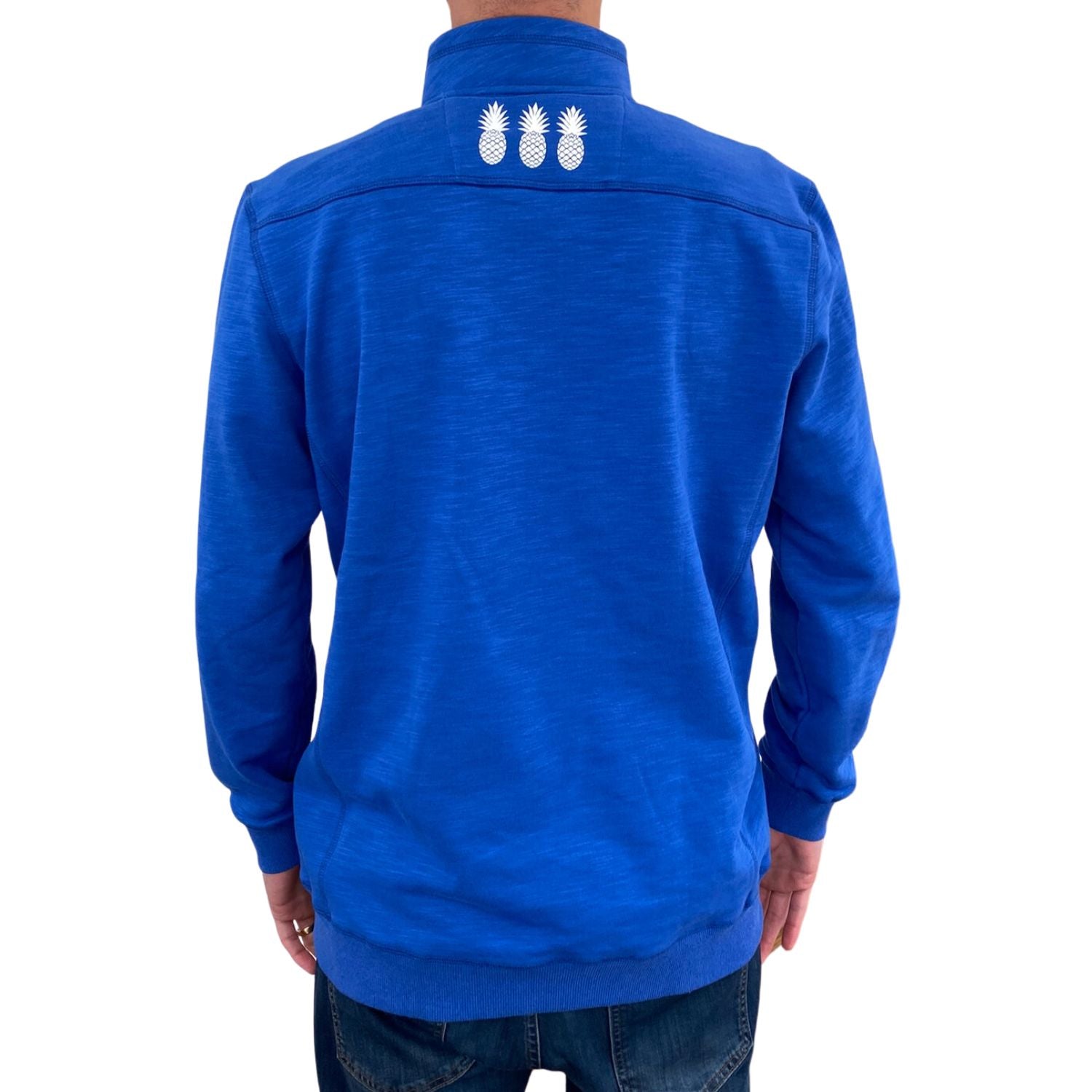 Blue jacket with white pineapple designs on the back against a white background