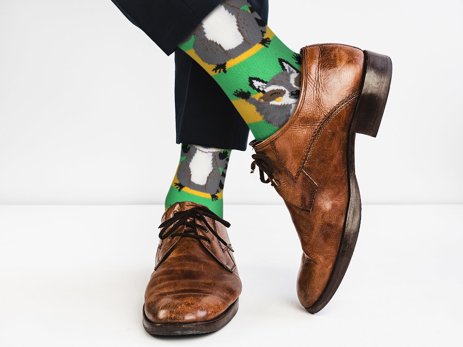 Brown dress shoes and colorful socks with animal design on a white background