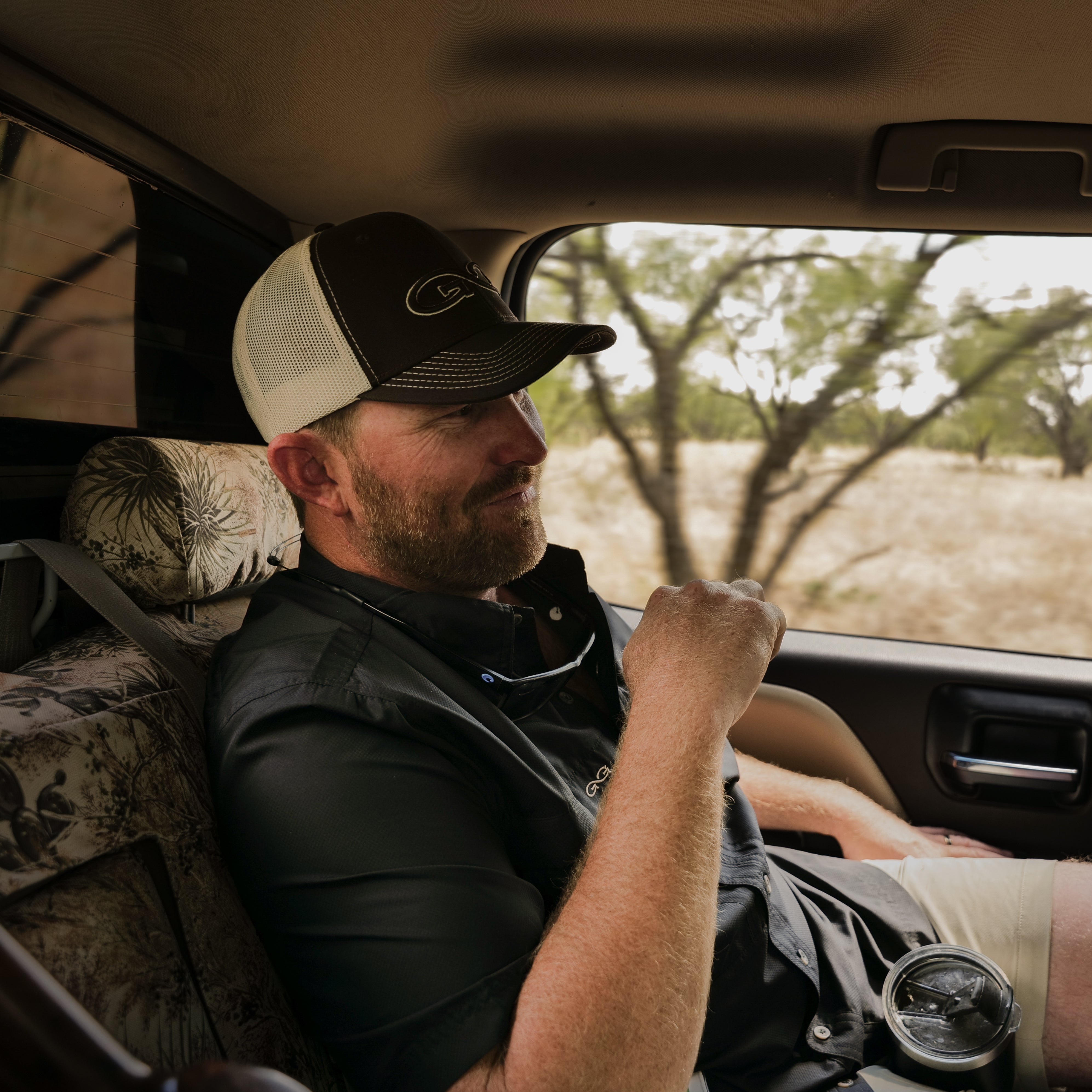 Man sitting in a car with a scenic background