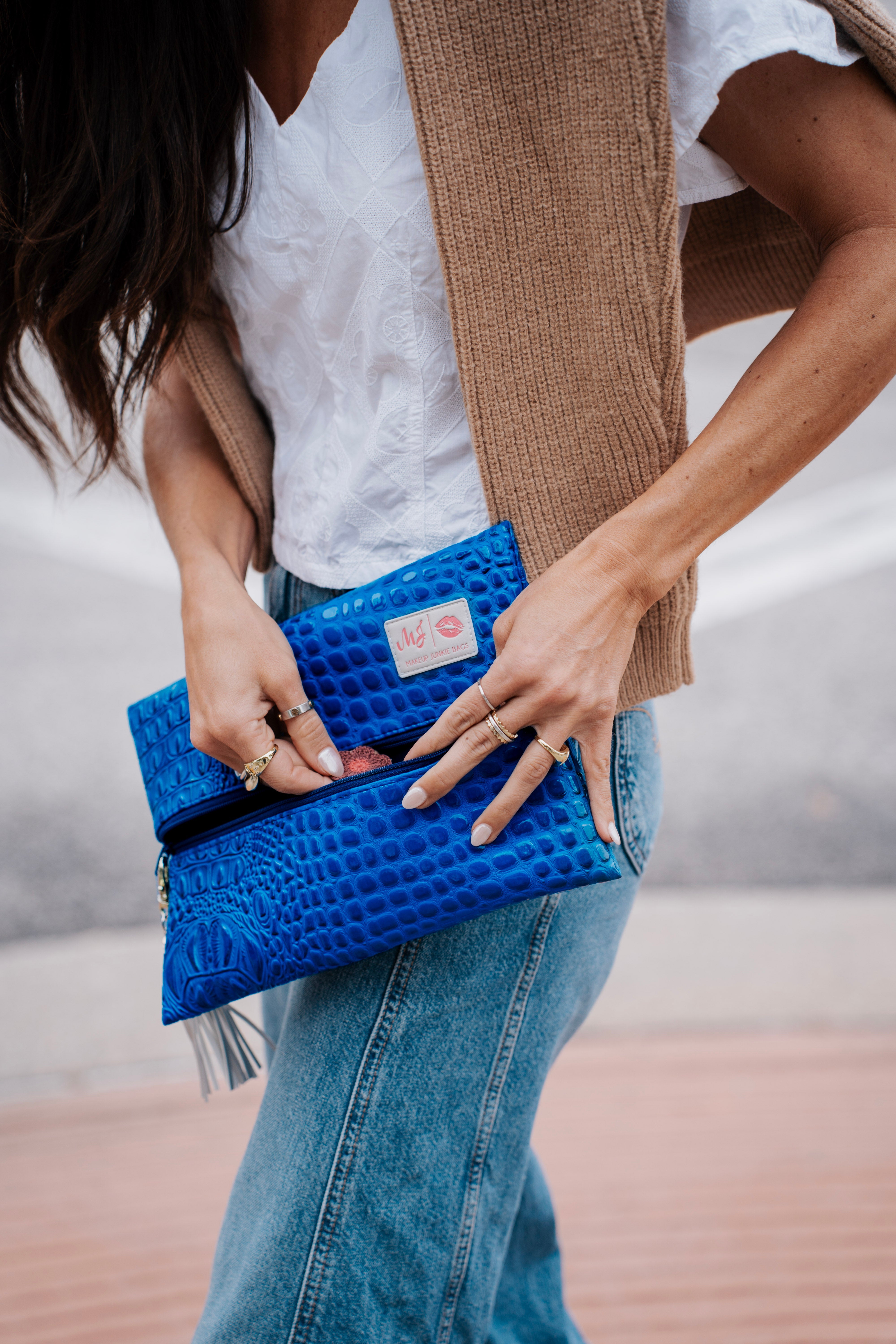 Person holding a blue clutch with a blurred background