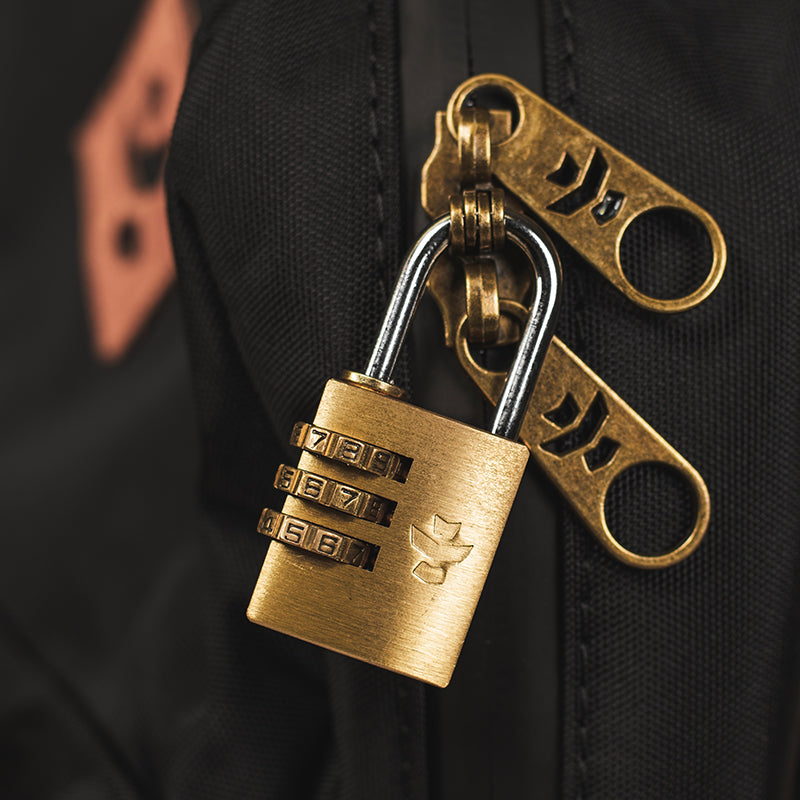 Gold combination lock and keychain on a dark background