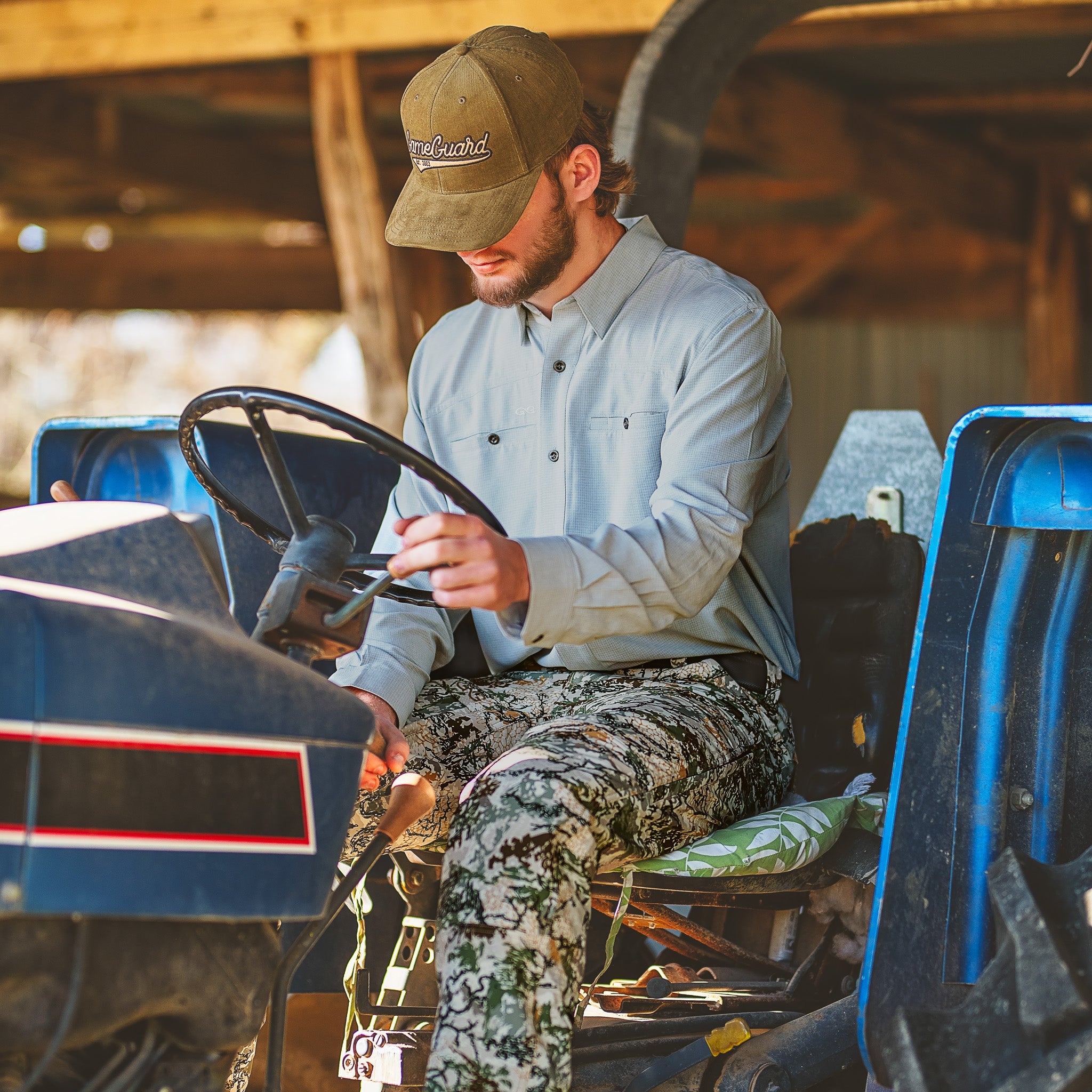 Man sitting on a four-wheeler in a barn-like setting