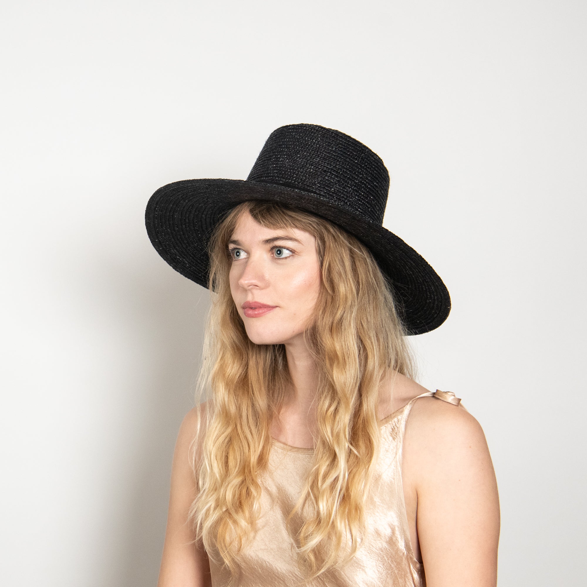 Woman wearing a black hat against a white background