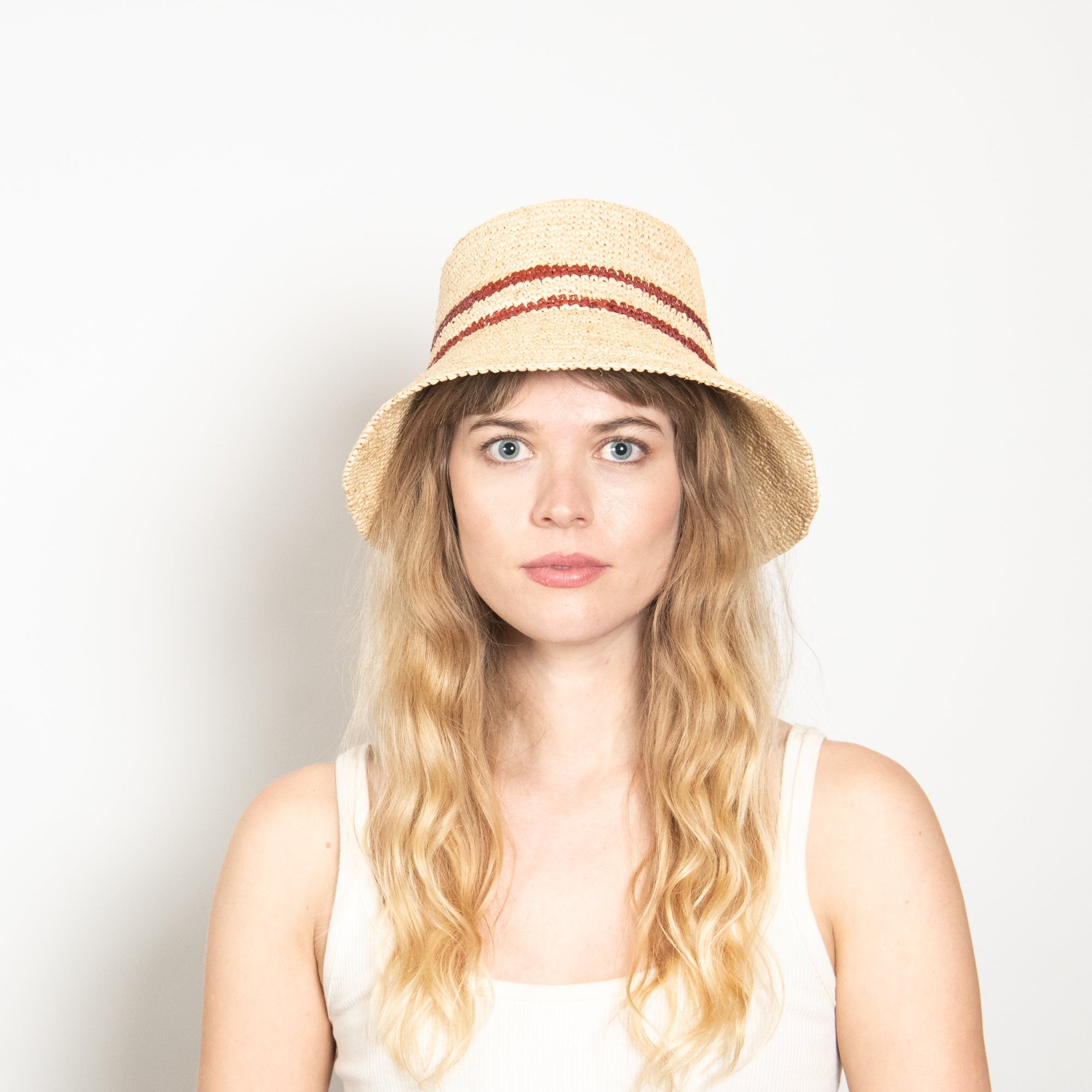 Woman wearing a straw hat with a plain background