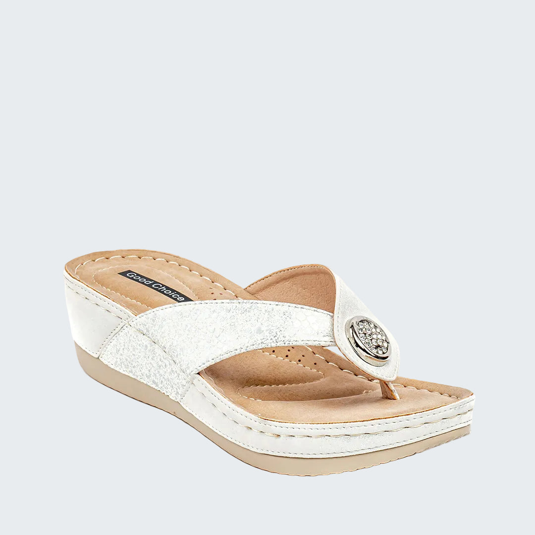White sandal with a decorative button on a white background