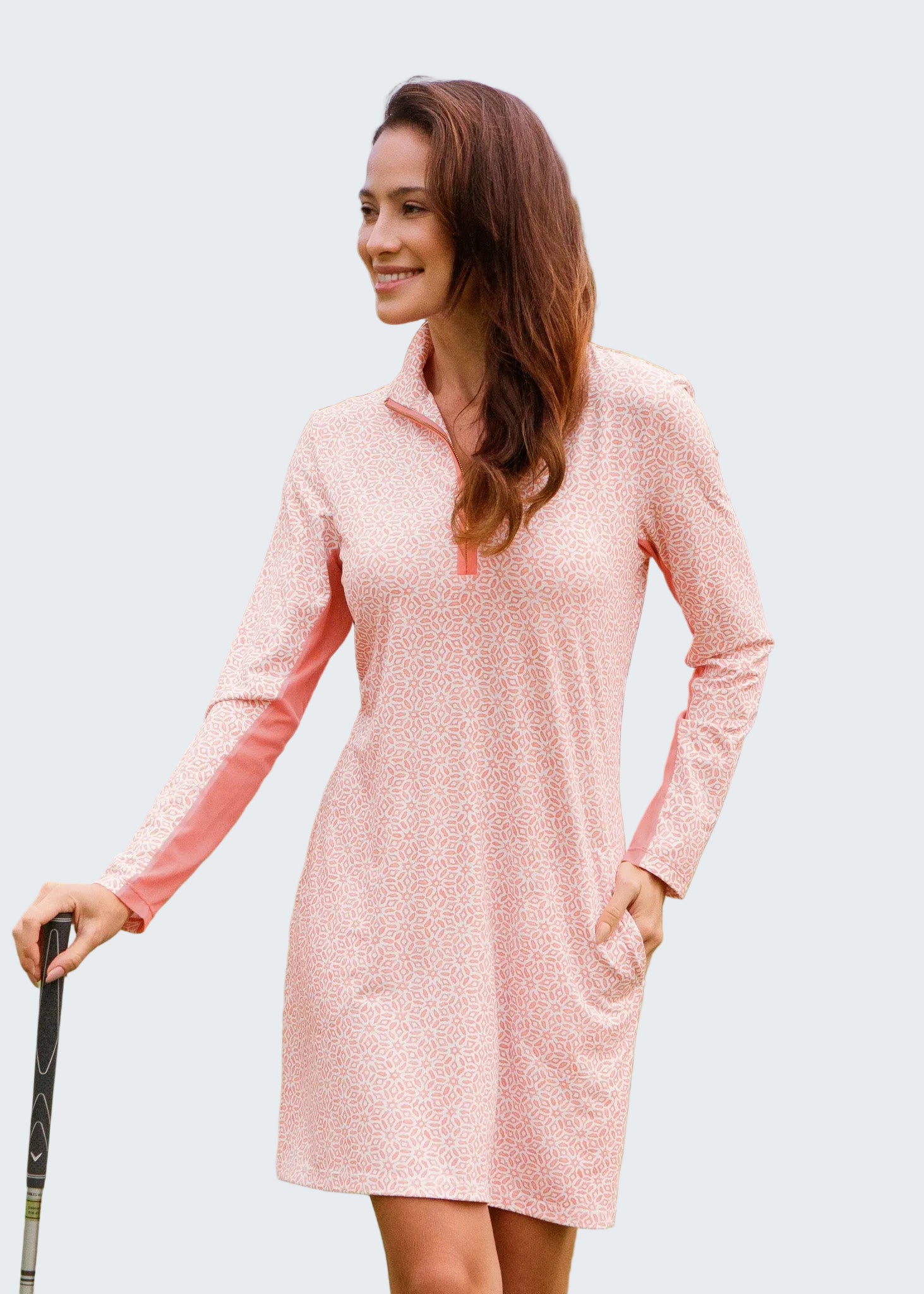 Woman in a pink dress standing on a golf course