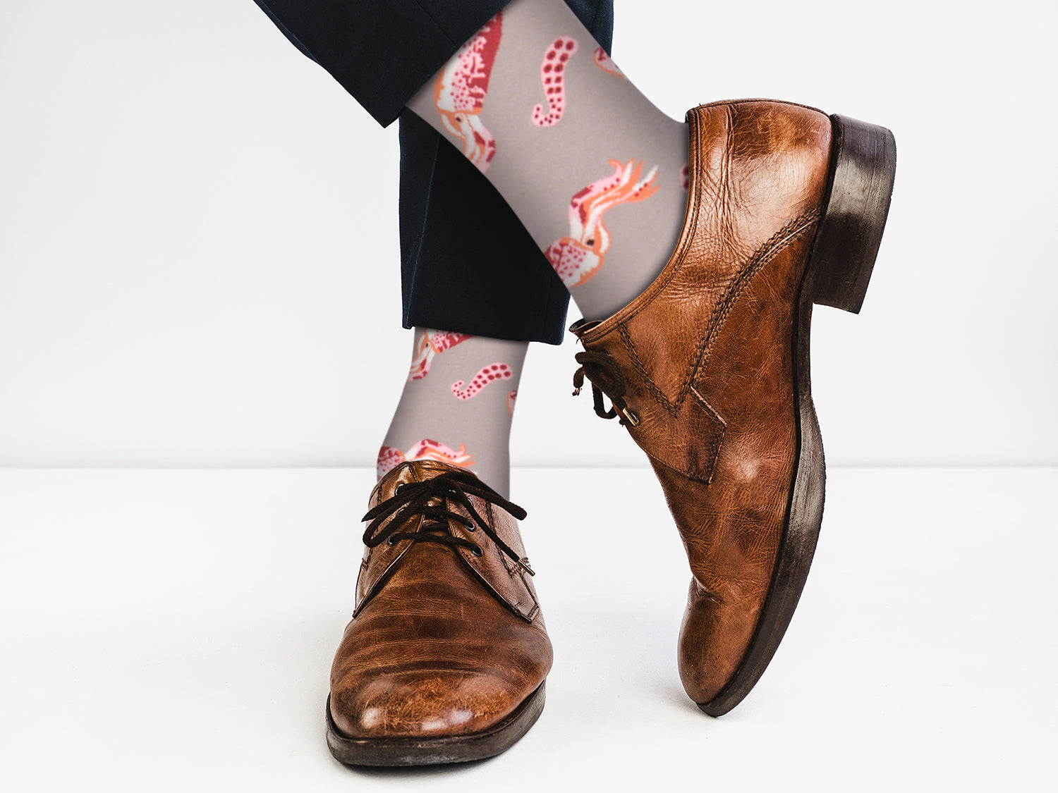 Brown leather shoes with patterned socks on a white background