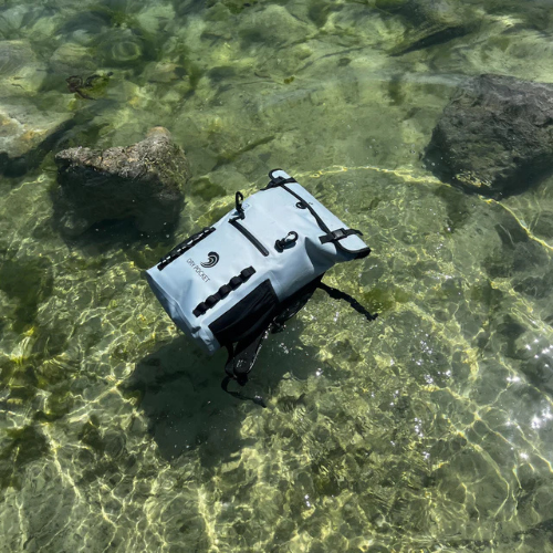 Waterproof bag on a bed of clear water with rocks