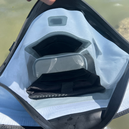 Black face mask inside a clear plastic bag with a natural background