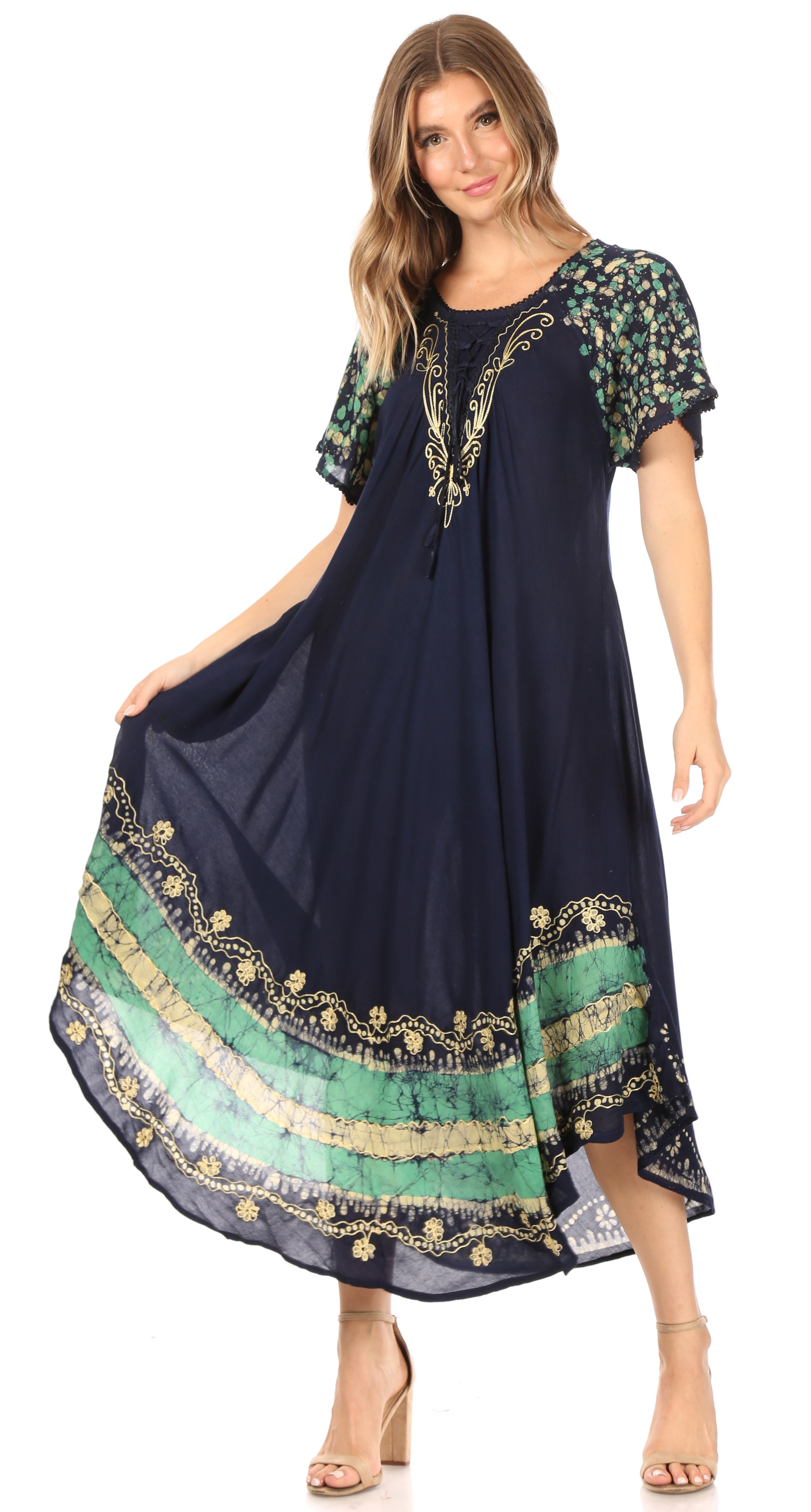 Woman wearing a navy dress with green and gold patterns on a white background