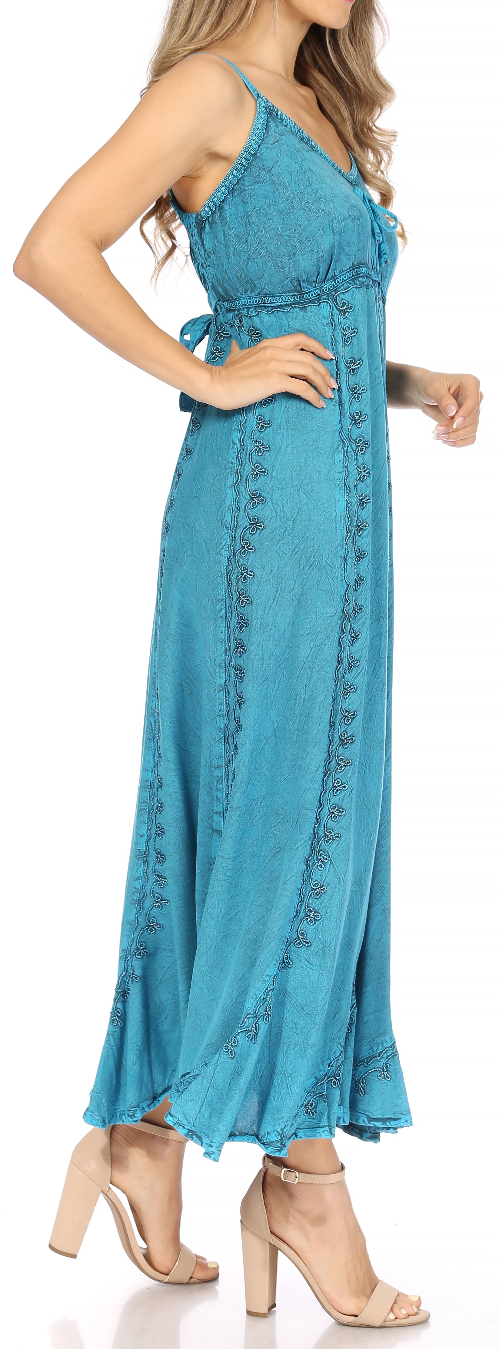 Woman wearing a blue dress with intricate detailing on a white background