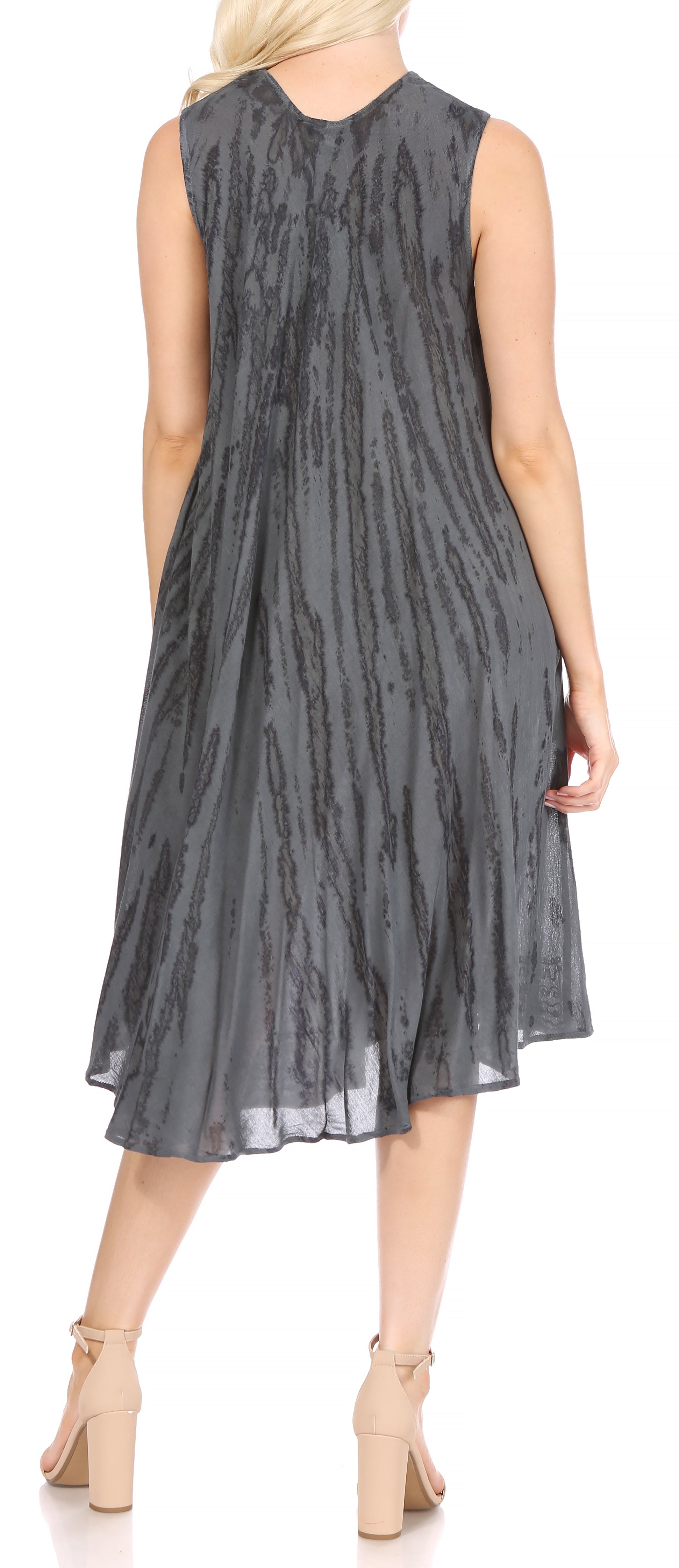 Woman wearing a sleeveless, patterned dress on a white background