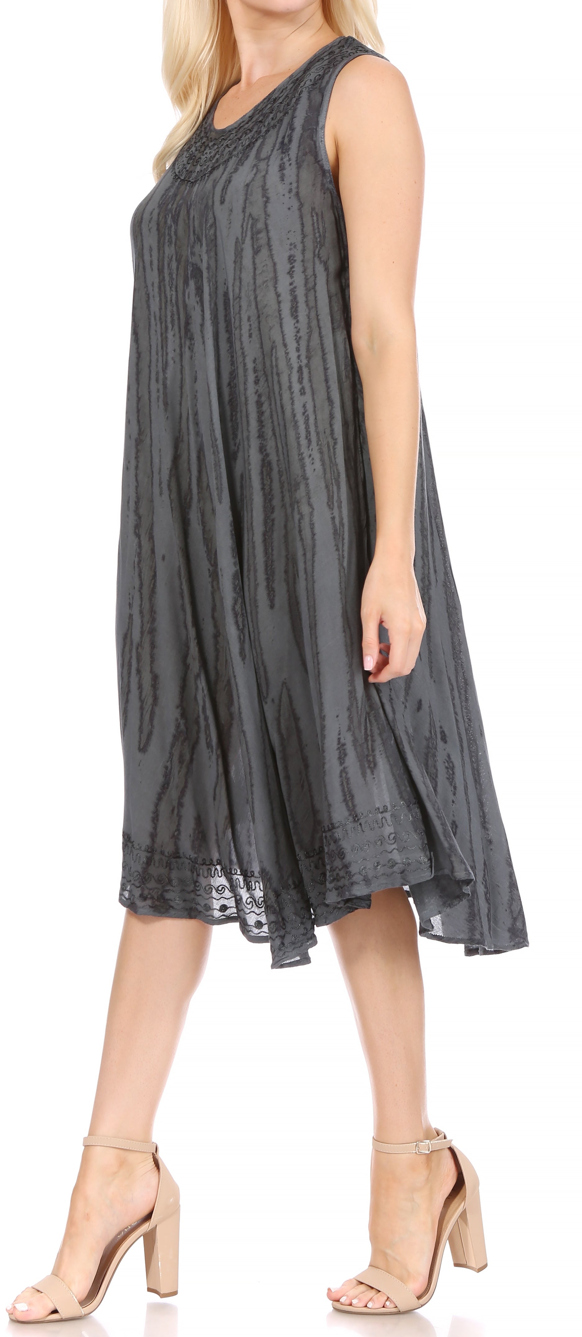 Woman wearing a sleeveless, dark gray dress with lace details on a white background