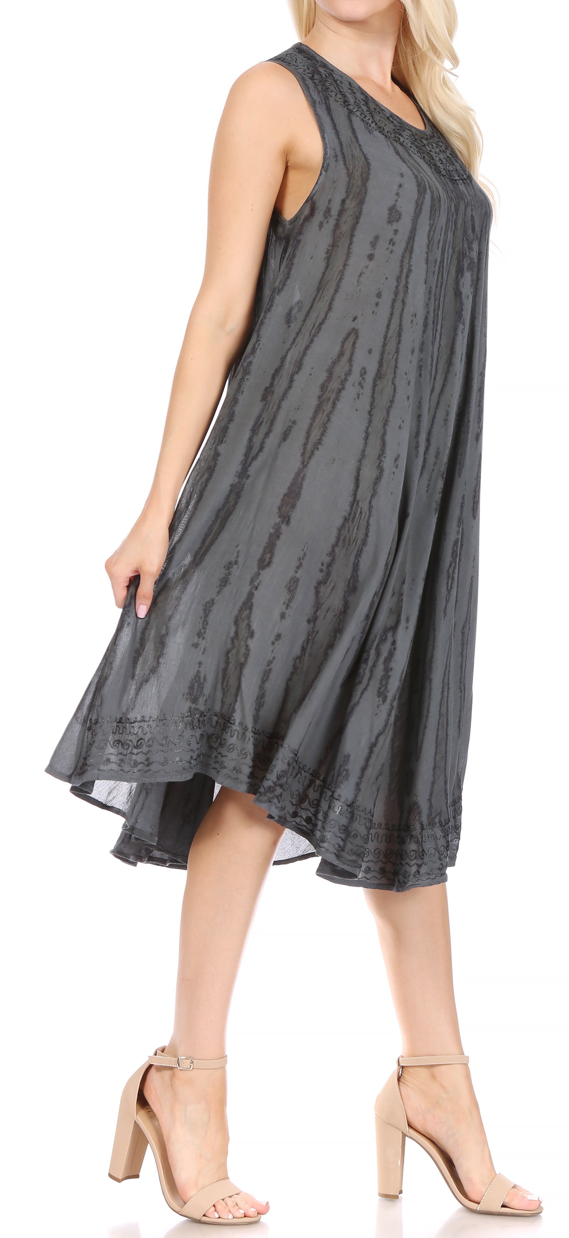 Woman wearing a sleeveless gray dress with a subtle pattern on a white background