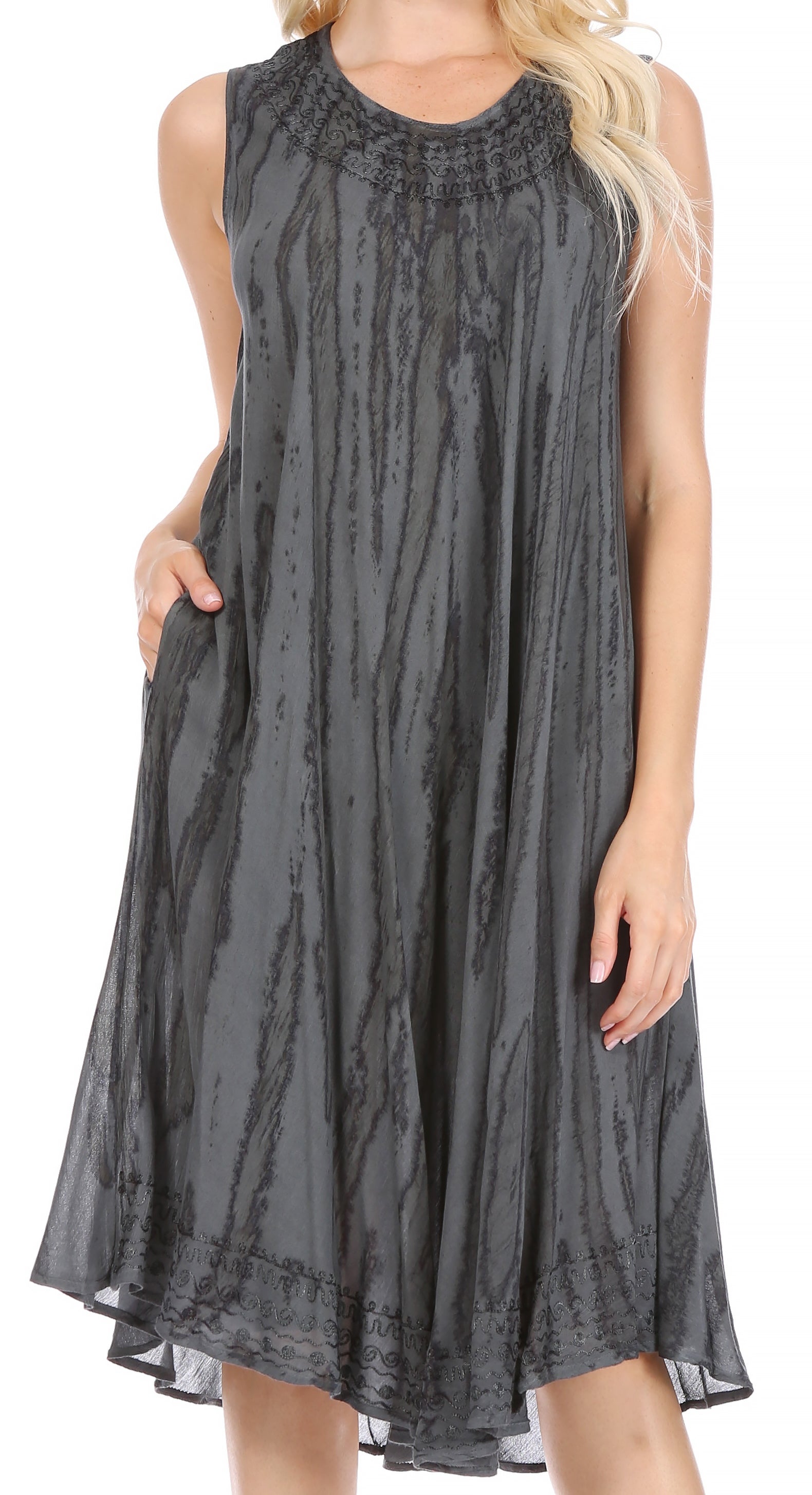 Woman wearing a sleeveless gray dress with a subtle pattern on a white background