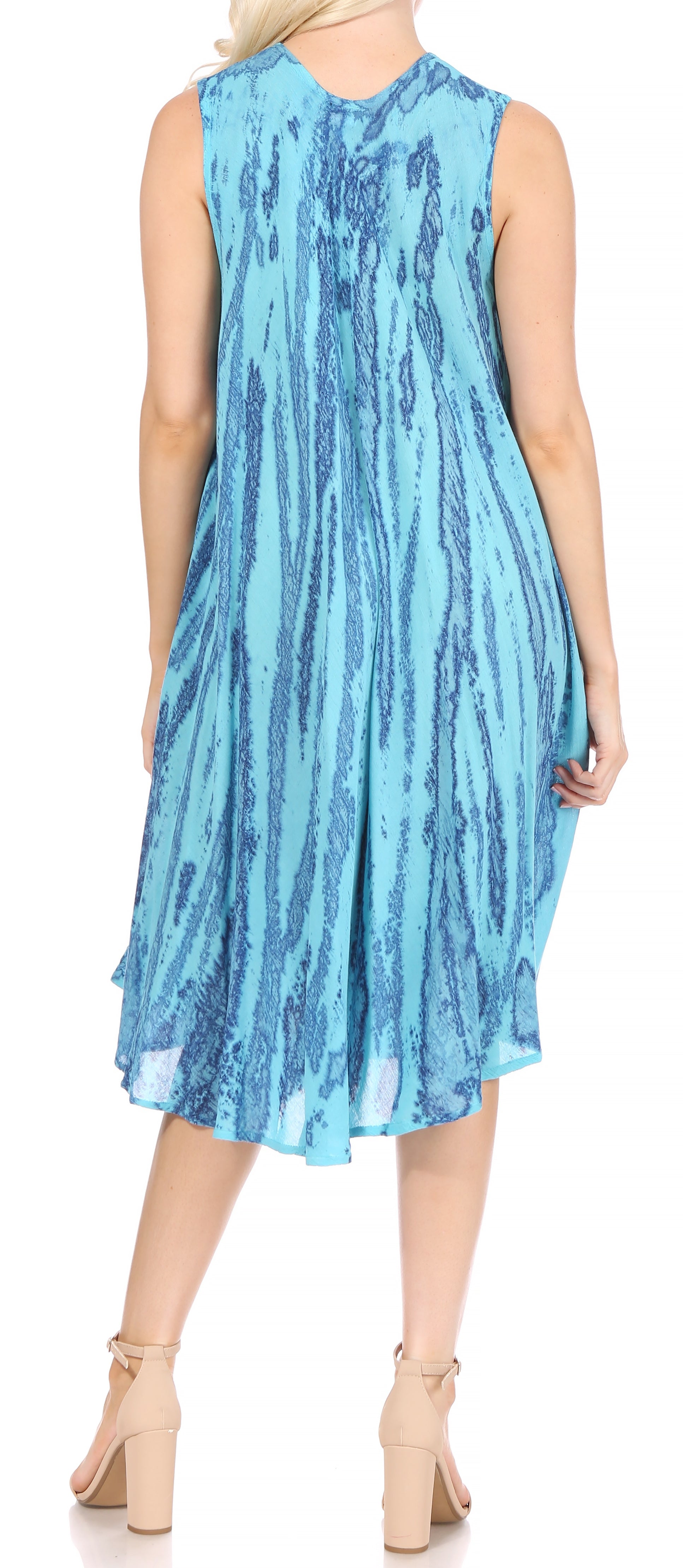 Woman wearing a blue sleeveless dress with a pattern on a plain background