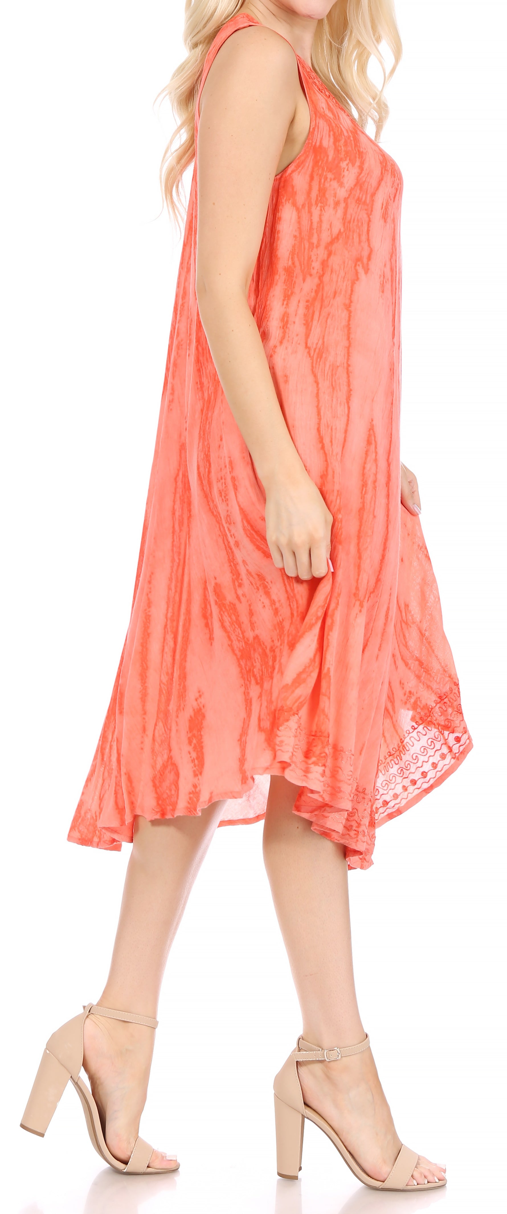 Woman wearing a coral dress with lace details on a white background