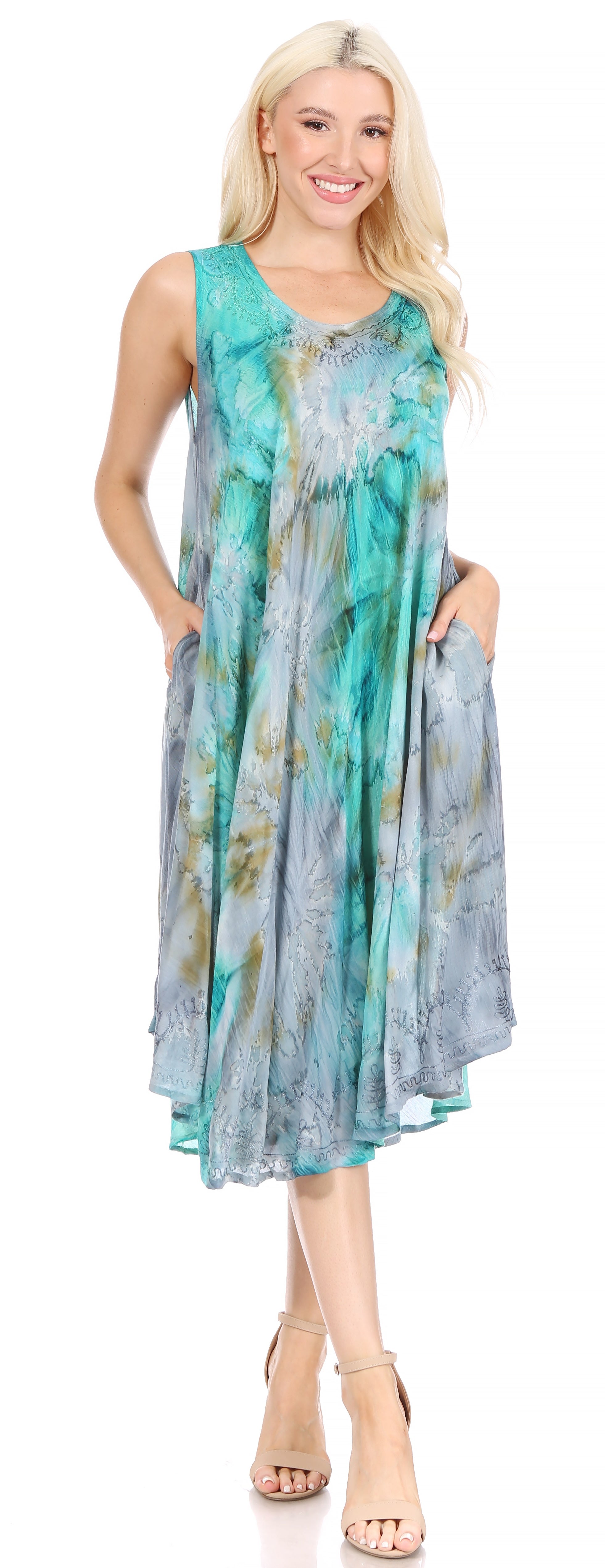 Woman wearing a sleeveless, floral-patterned dress with a blue and green color scheme.