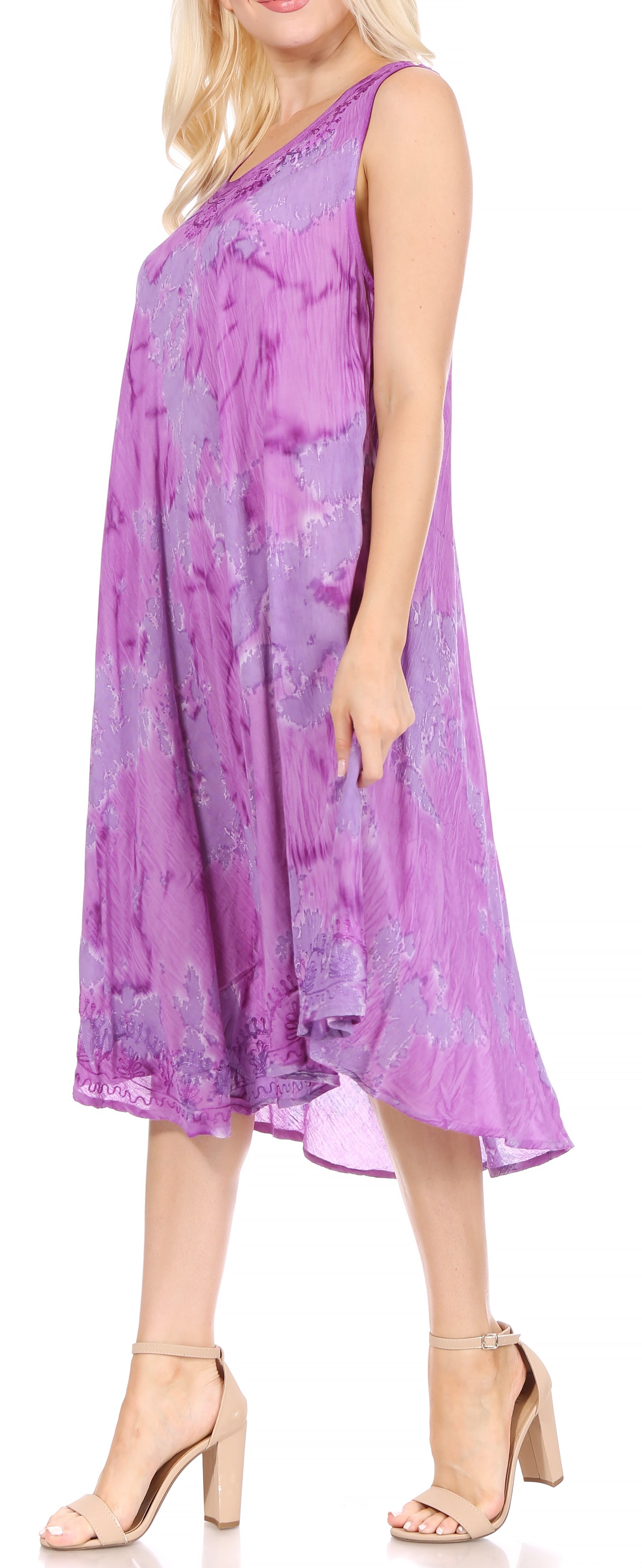 Woman wearing a purple tie-dye dress with beige sandals on a white background