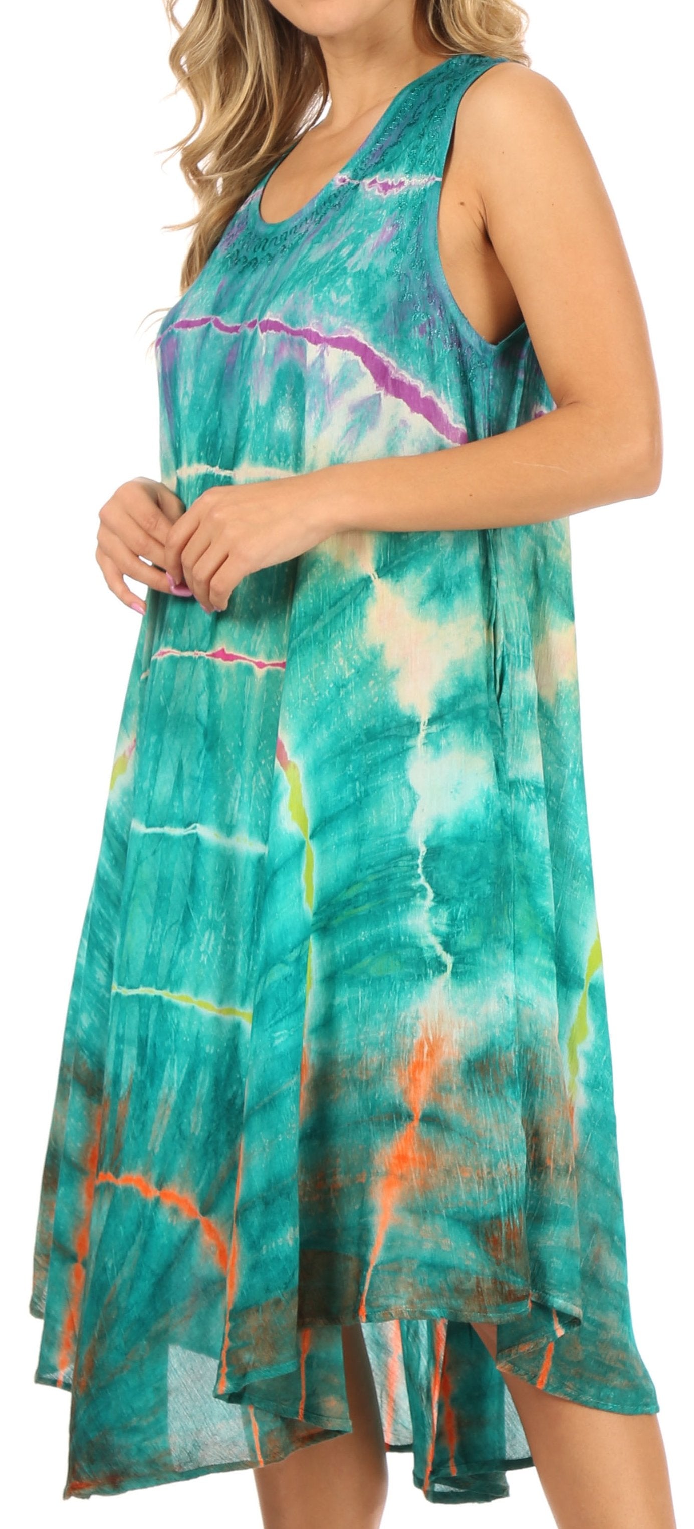Woman wearing a tie-dye dress with a colorful pattern on a plain background